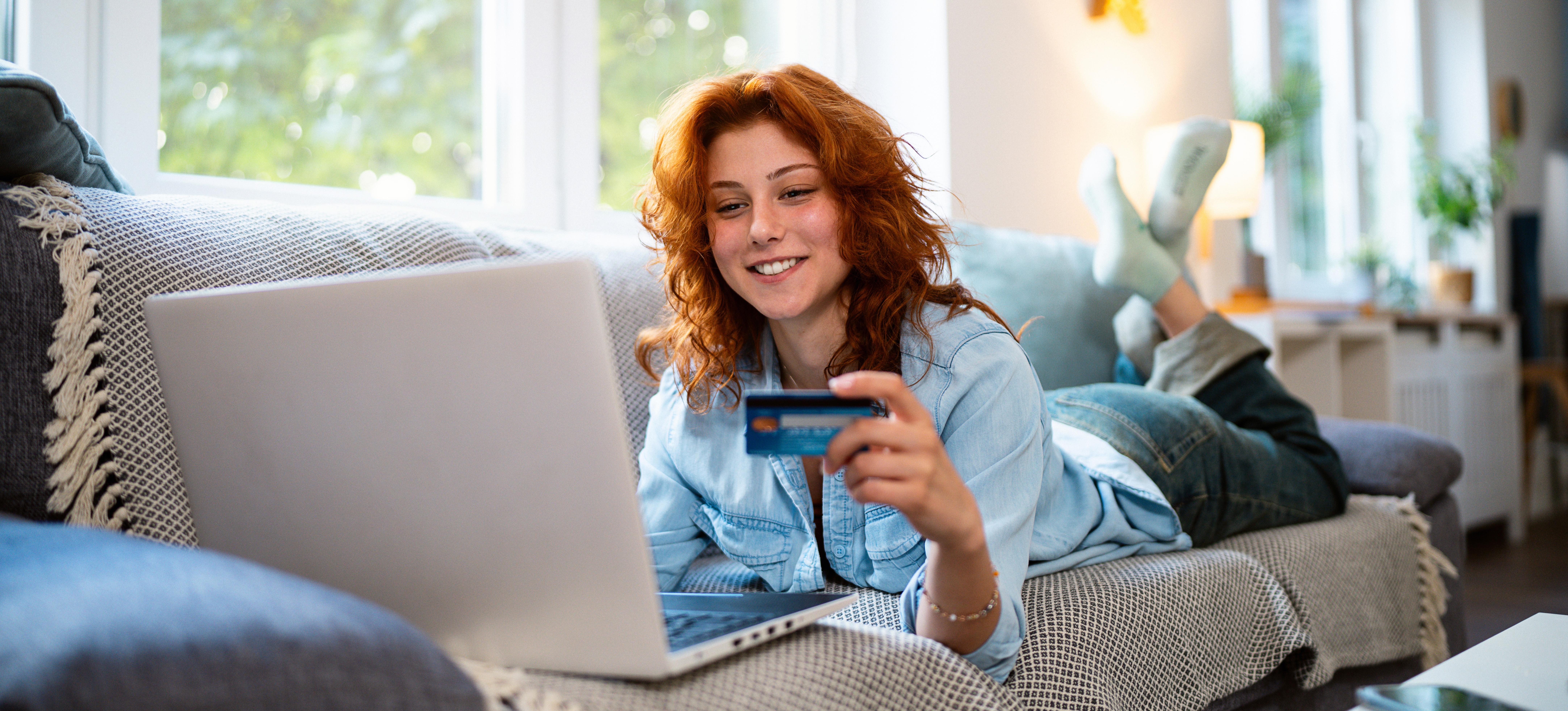 [Featured Image] Woman uses fintech to purchase something online from her device in the comfort of her home.