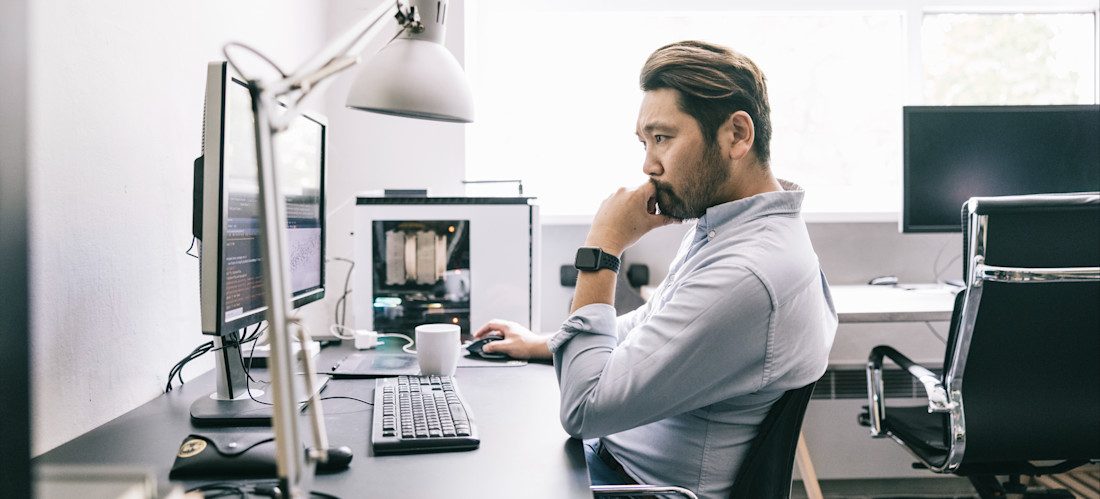 [Featured Image] An AI engineer sits at a desk working on a computer and pondering the task at hand.