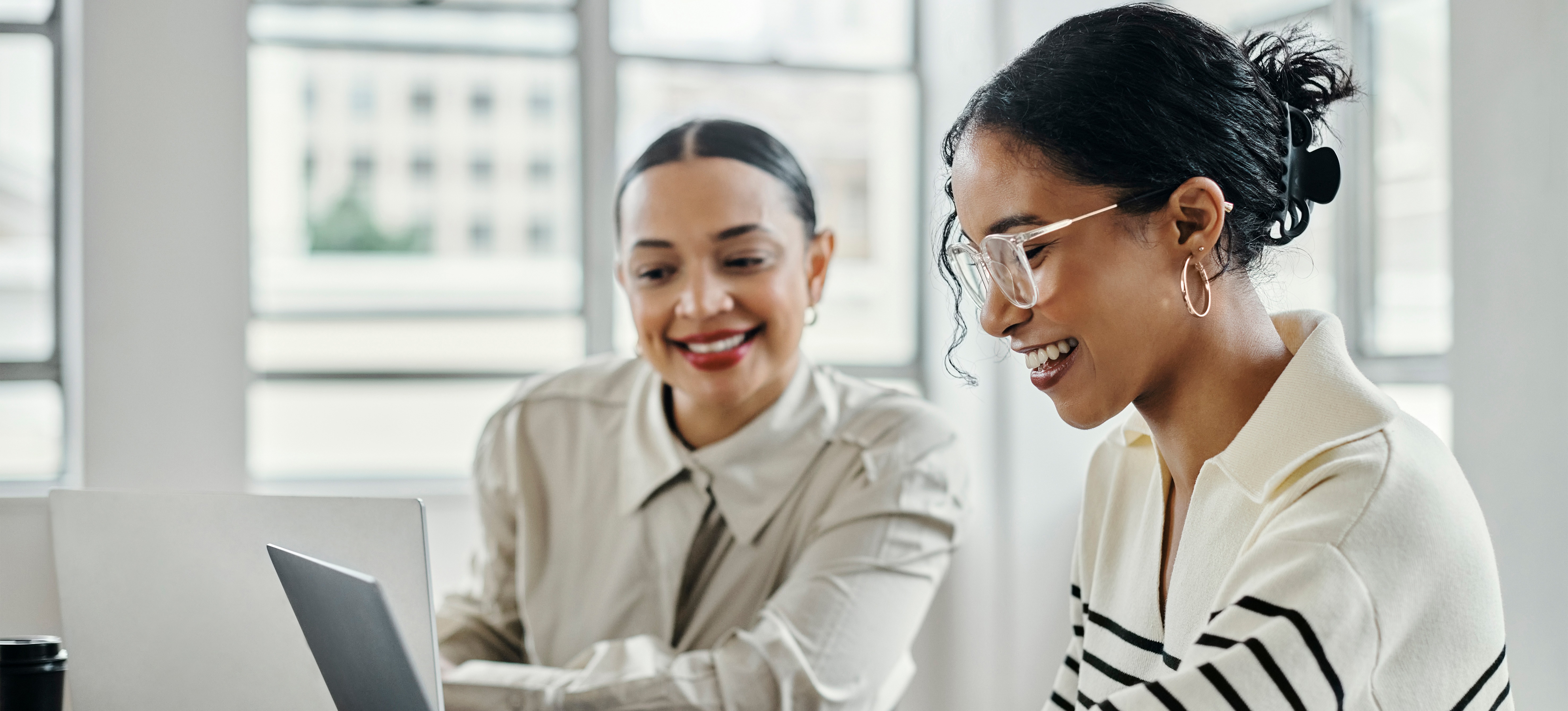 [Featured Image] Two college students review marketing terms on a computer.
