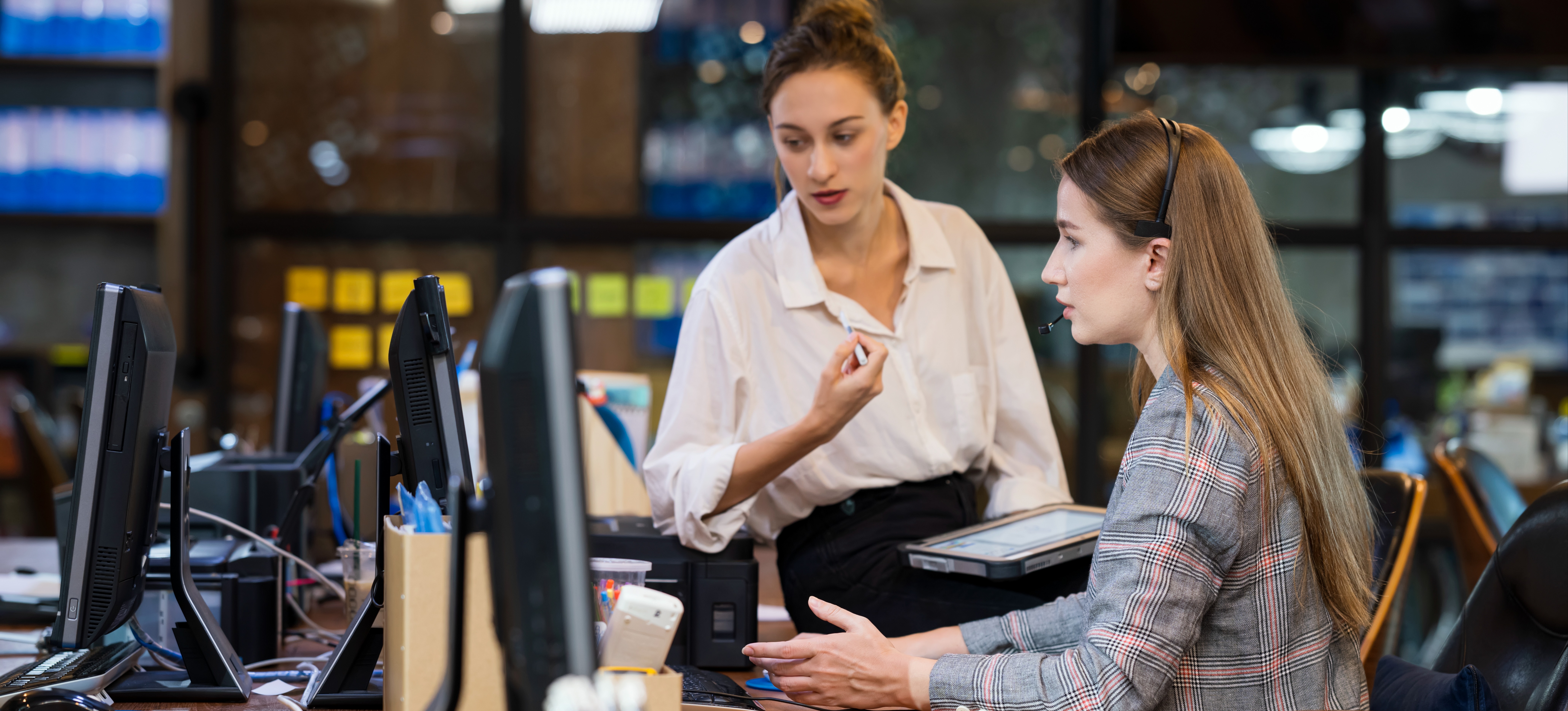 [Featured image] Two computer experts looking at a computer and discussing endpoint security.
