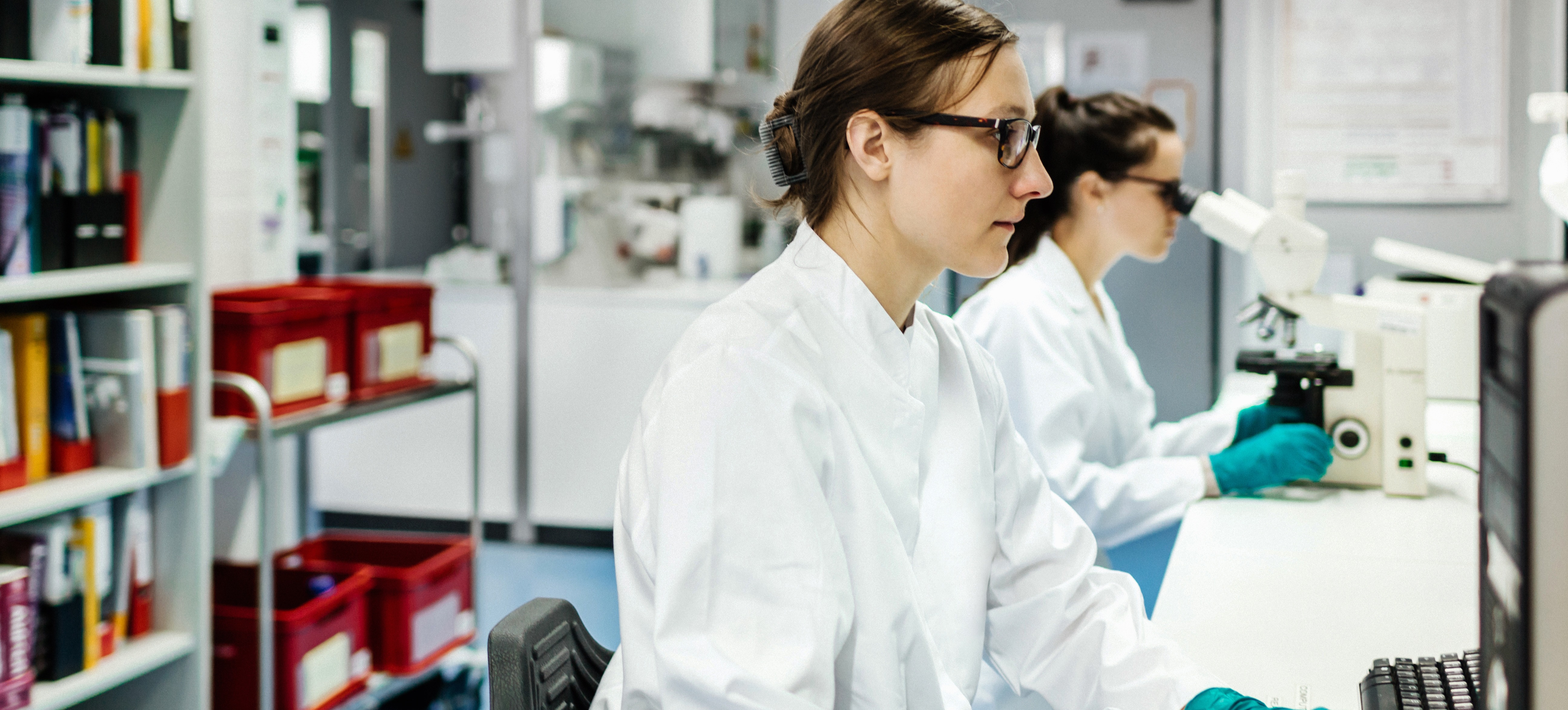 [Featured image] Biomedical engineers examine slides through microscope 