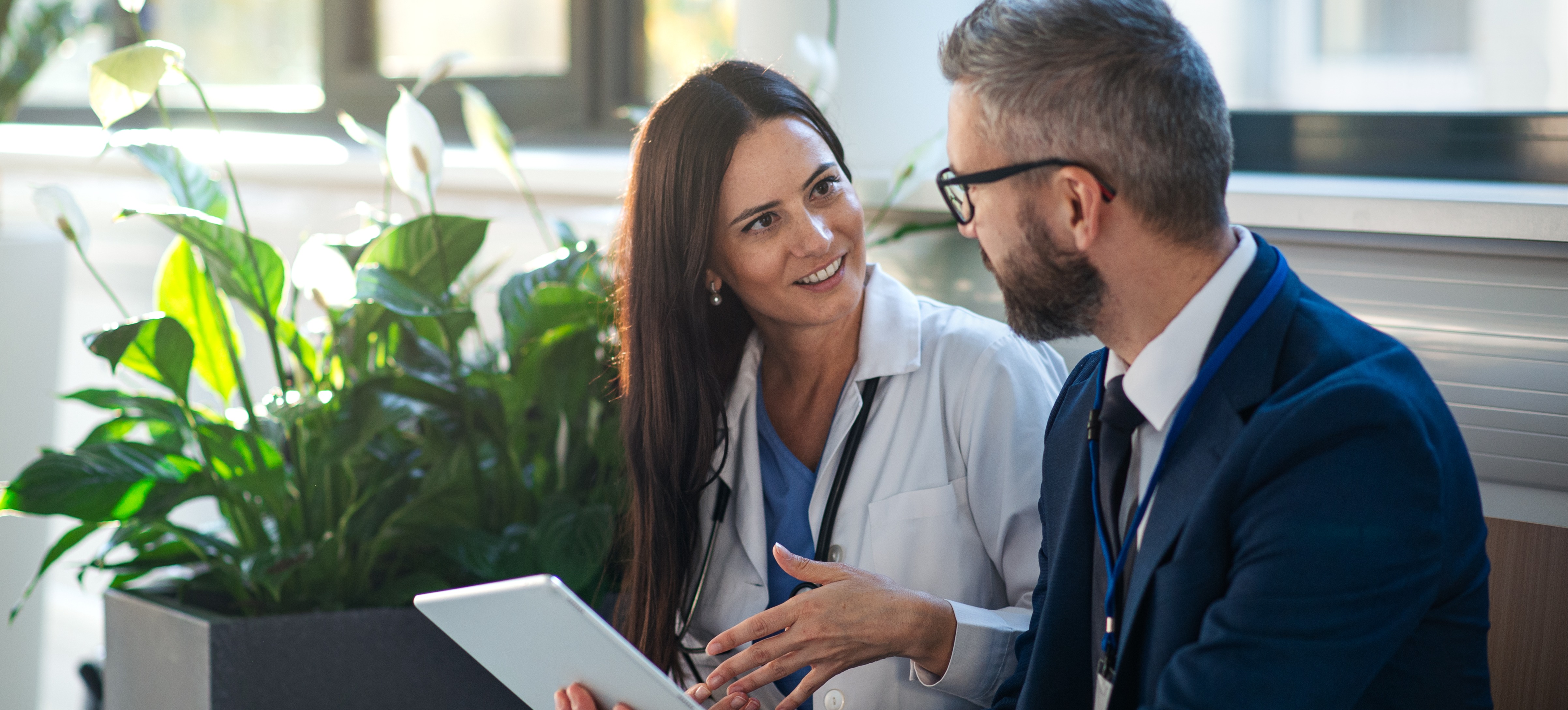 [Image en vedette] Un représentant commercial utilise la technique de vente par argumentaire pour comprendre comment ses produits résoudront les problèmes de son client qui est médecin.