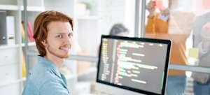 [Featured image] A programmer in a blue shirt enumerates a list in Python on his desktop computer.