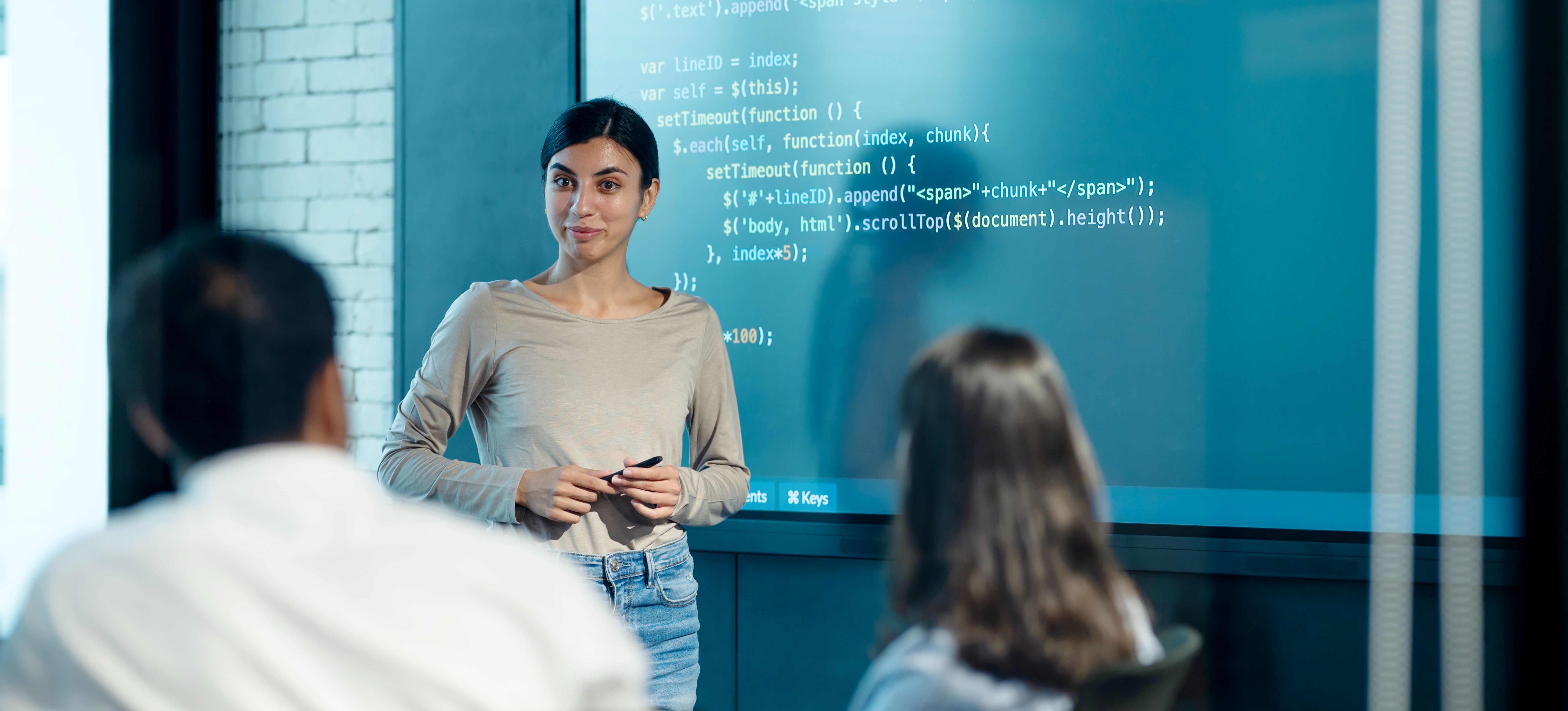 [Featured Image] A software developer is in a meeting discussing the real-time data report available through new AI project management tools.
