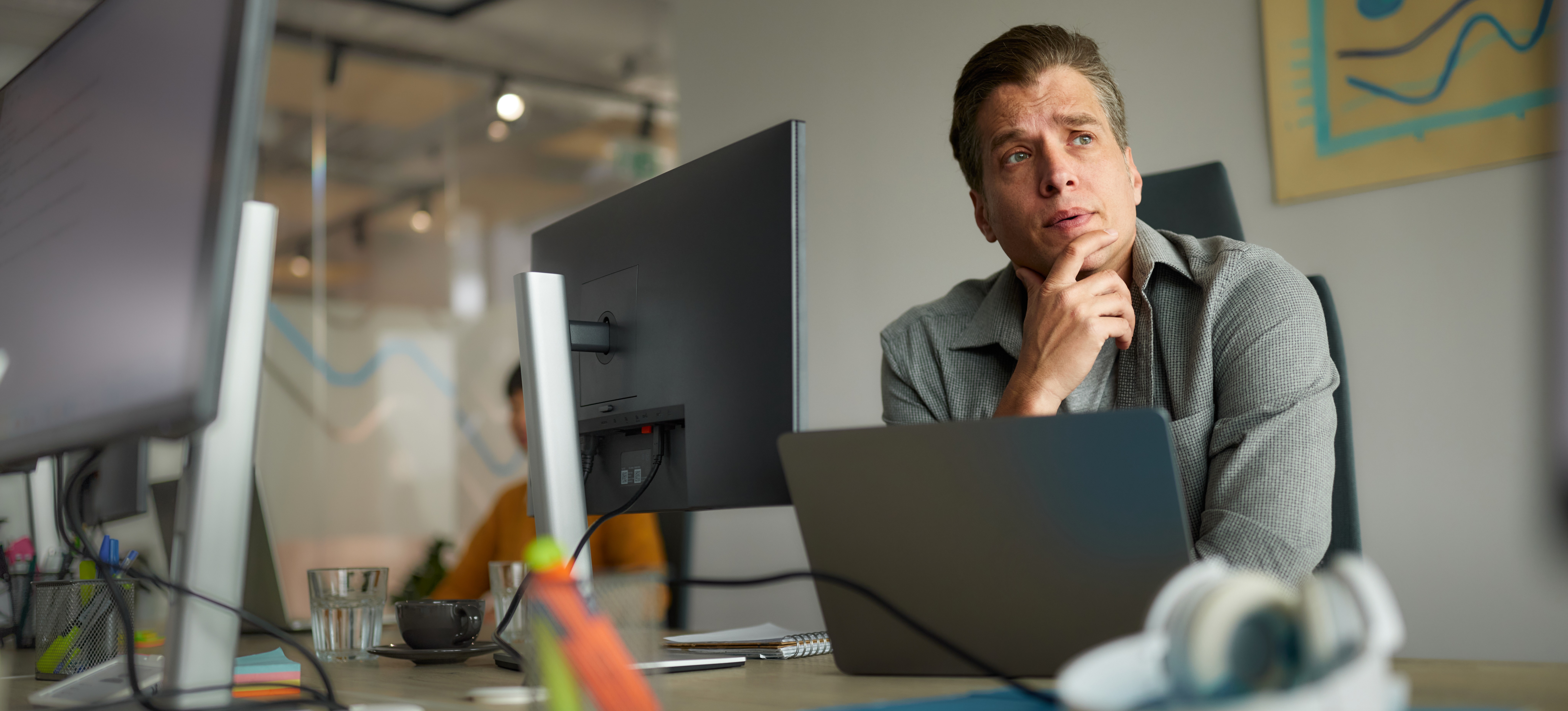 [Featured image] An RPA developer at a computer thinks about ways to improve customer service with a bot.
