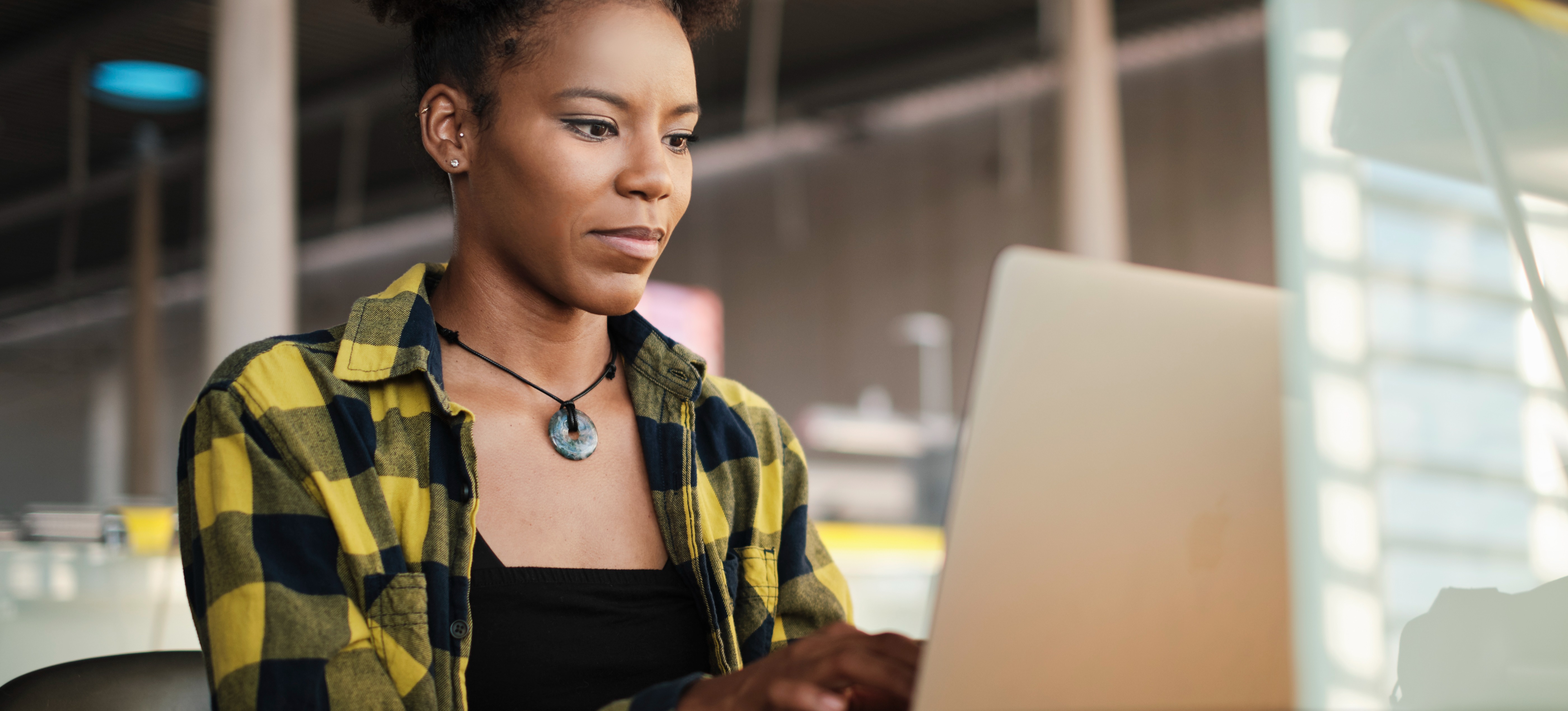 [Featured image] A college student sits at her laptop in a library as she contemplates if she can get a bachelor's degree in two years.