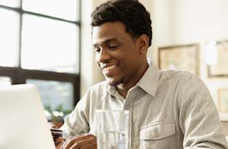 [Featured image] A man sits at a laptop earning his RHCSA certification.
