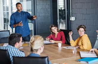 [Featured image] An operations manager leads a meeting in a company conference room.