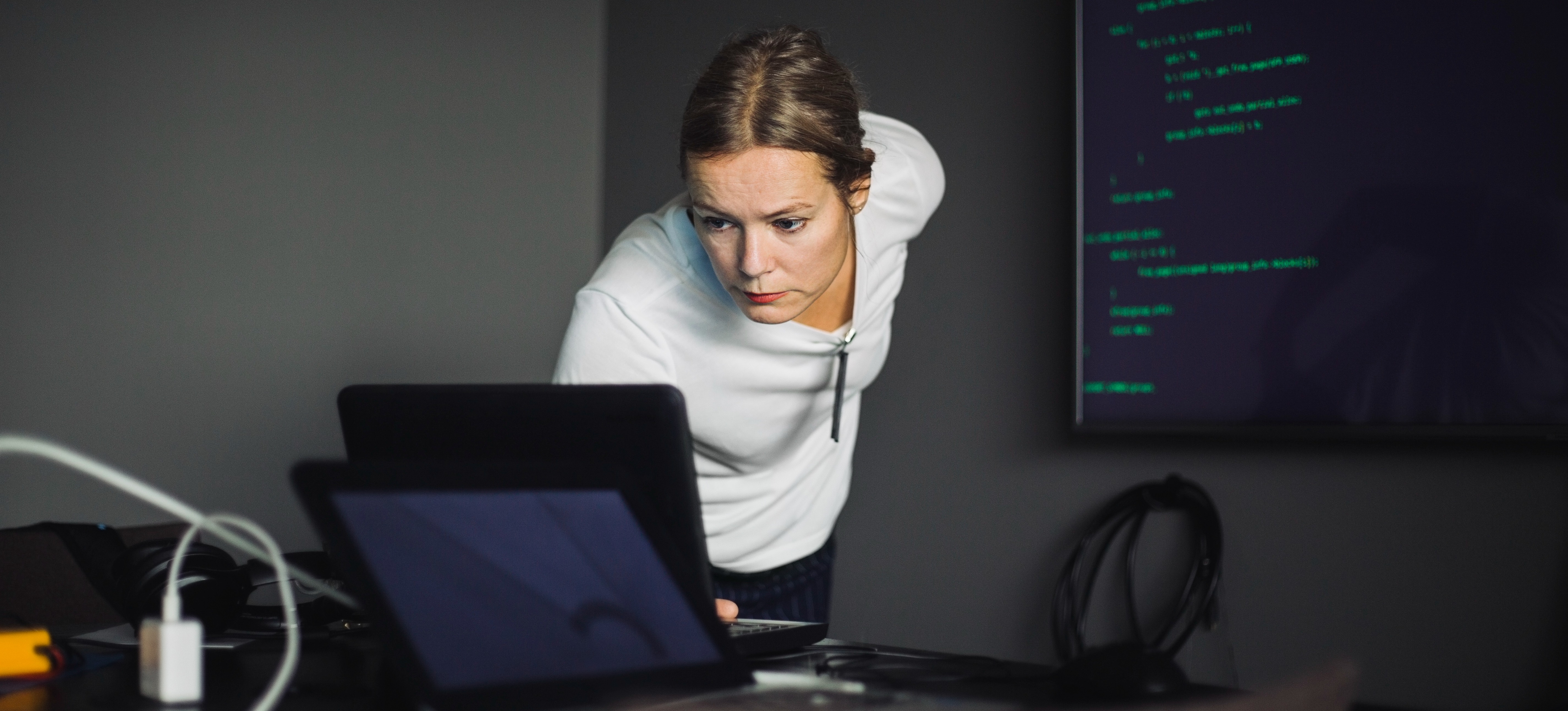 [Featured image] A cybersecurity expert who is a member of a purple team checks data on a laptop computer.