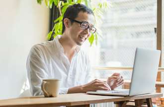 [Featured image] A cybersecurity engineer is working from home on his laptop.  