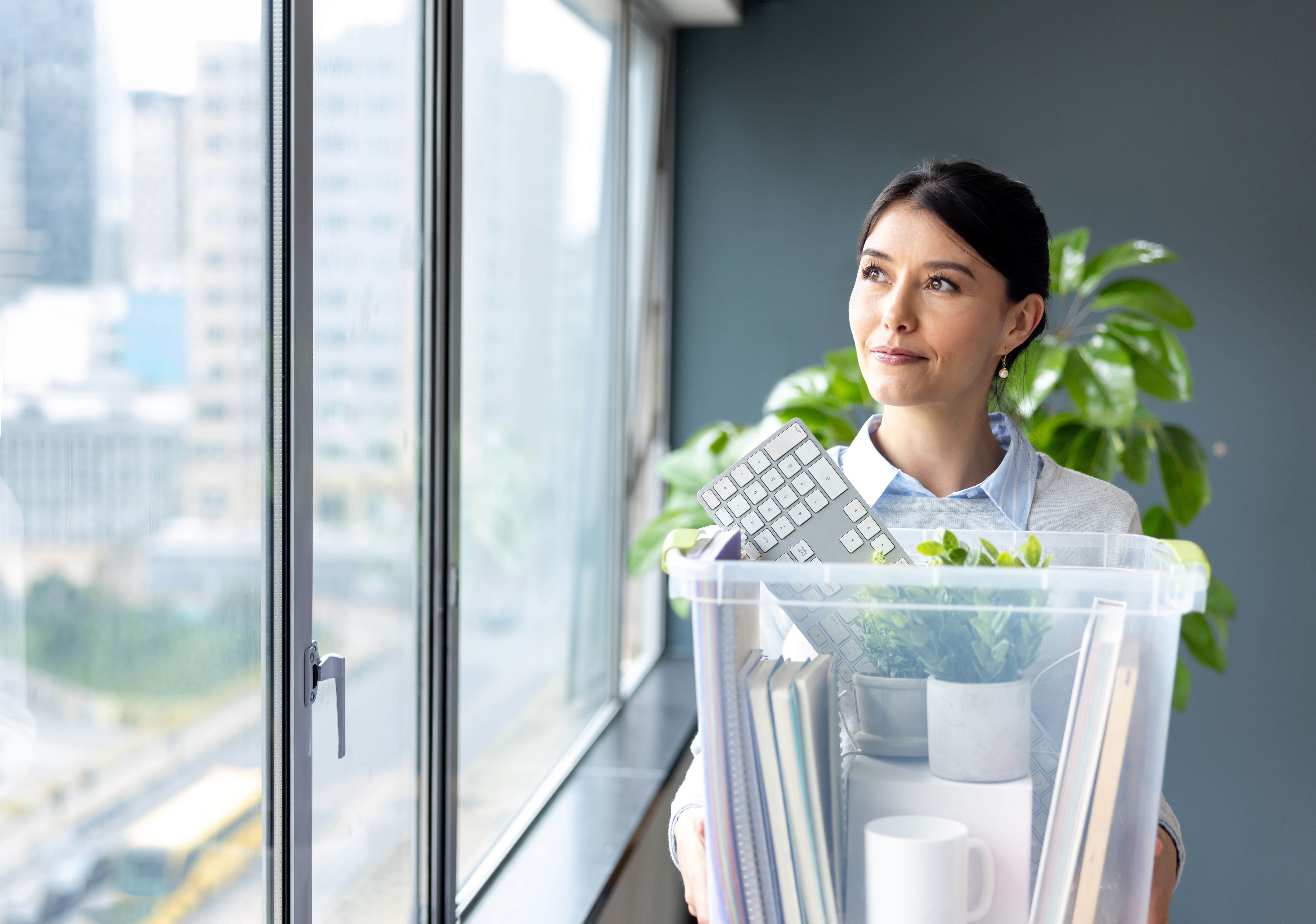 [Image en vedette] Un professionnel satisfait bénéficie de la mobilité interne, car il emporte ses affaires dans une boîte transparente et emménage dans son nouveau bureau.