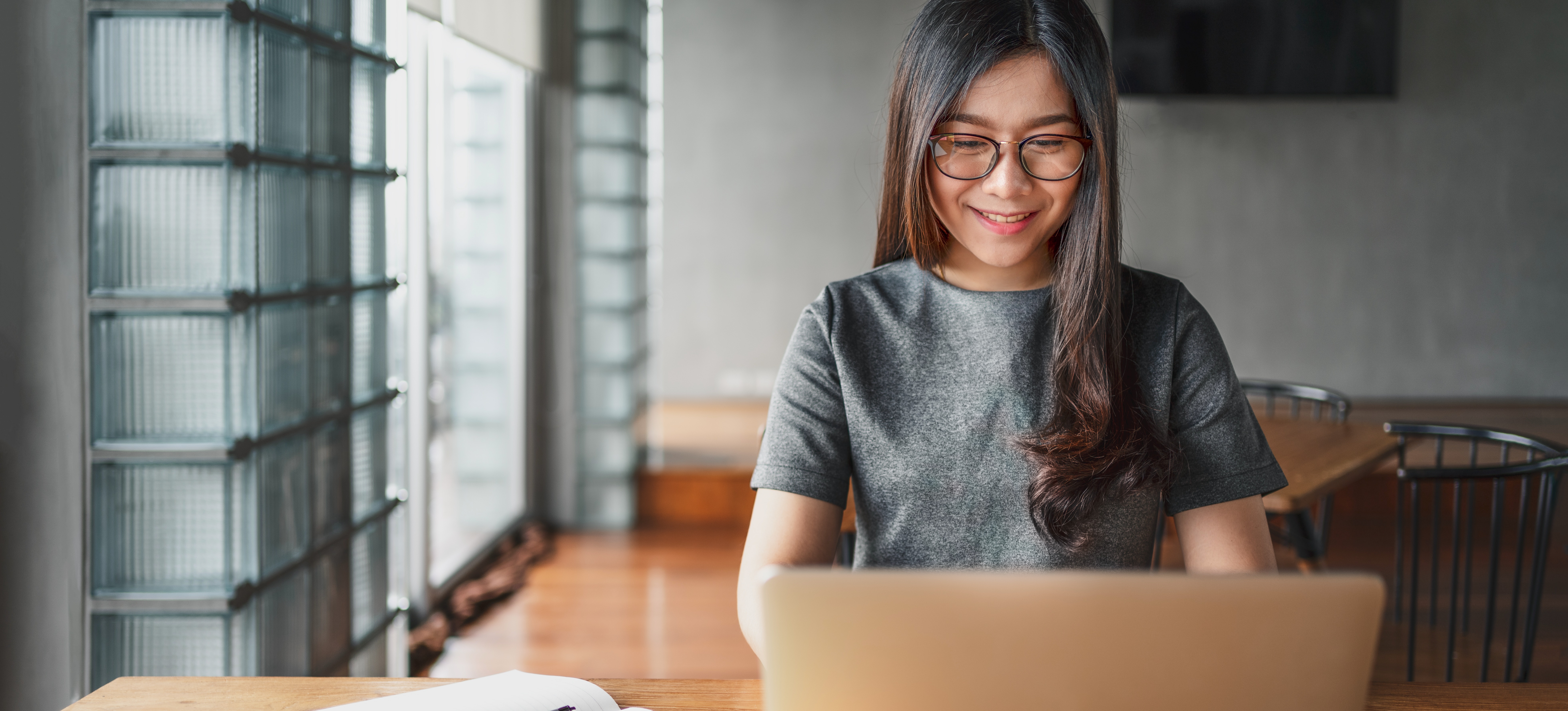 [Feature Image] A learner researches how to become a security architect and the average security architect's salary on a laptop while planning their education and career goals. 
