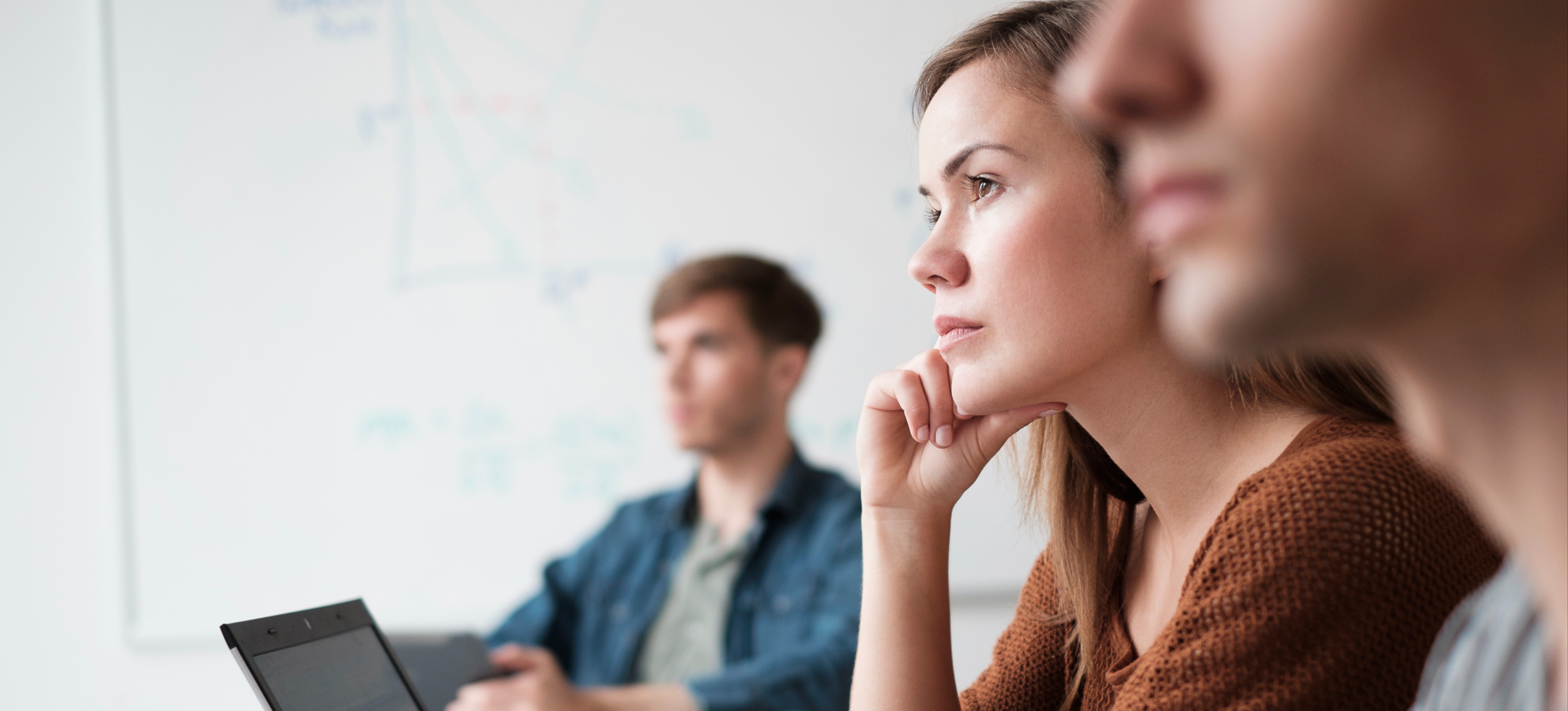 [Image en vedette] Une femme est assise, écoutant, avec un ordinateur portable ouvert devant elle, dans un cours de développement professionnel requis pour la certification CCNP.