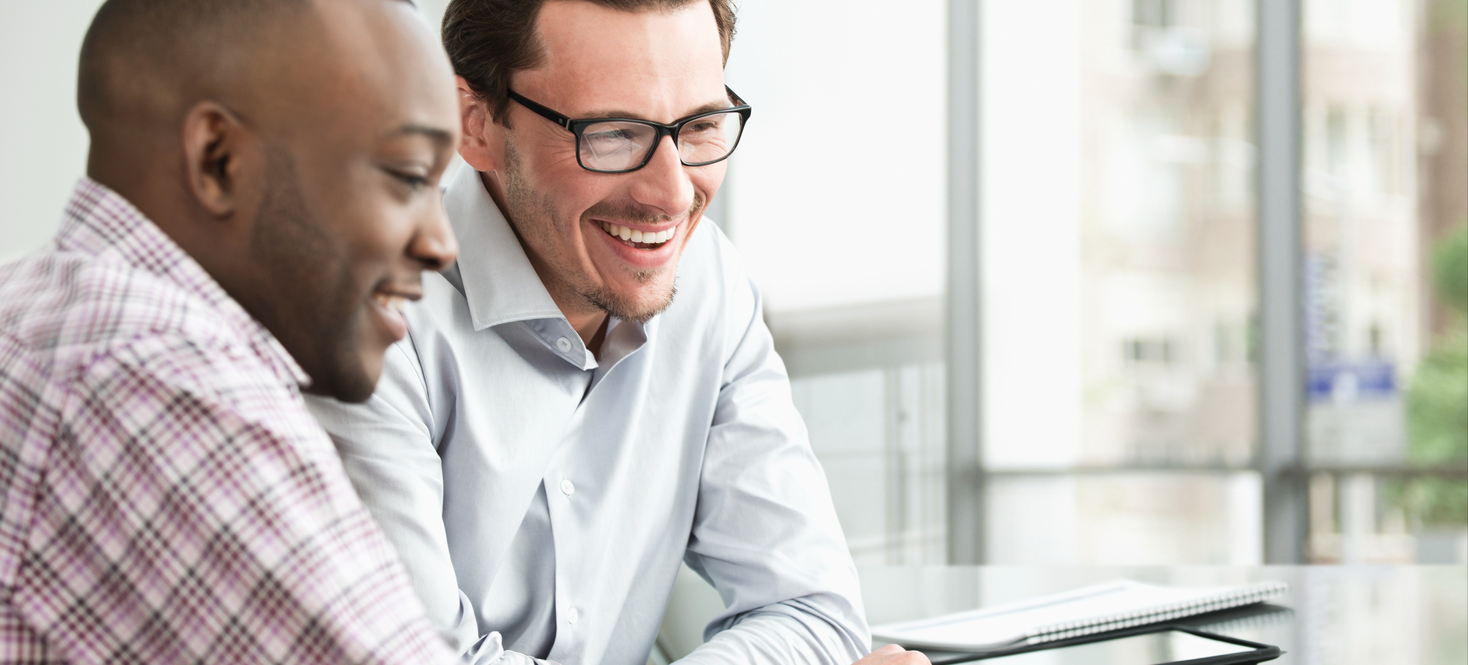 [Featured Image] Two SEO specialists sit at a table in a conference room and discuss the importance of stop words. 