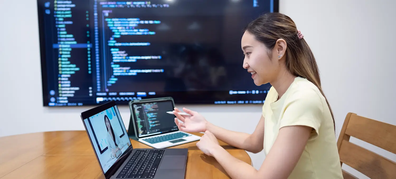 [Featured Image] An aspiring SQL developer engages with online learning, excitedly watching a lecture that helps them understand what SQL developers do in more detail.
