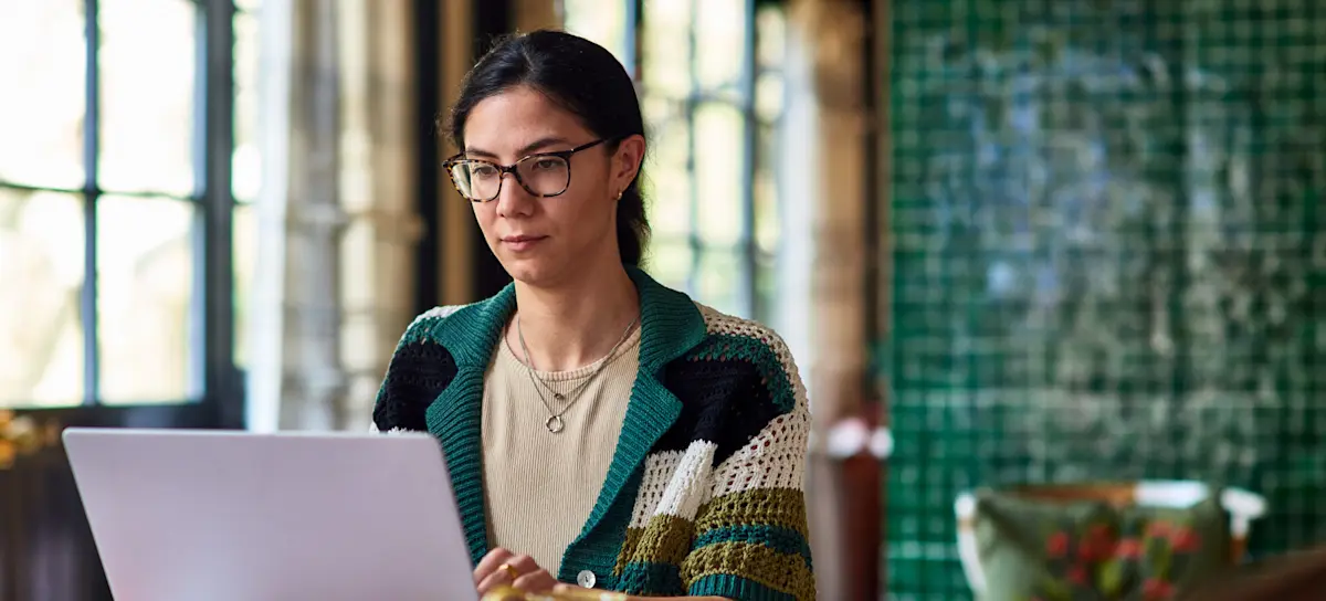 [Featured Image] A person is on a laptop learning how to lock cells in Google Sheets.