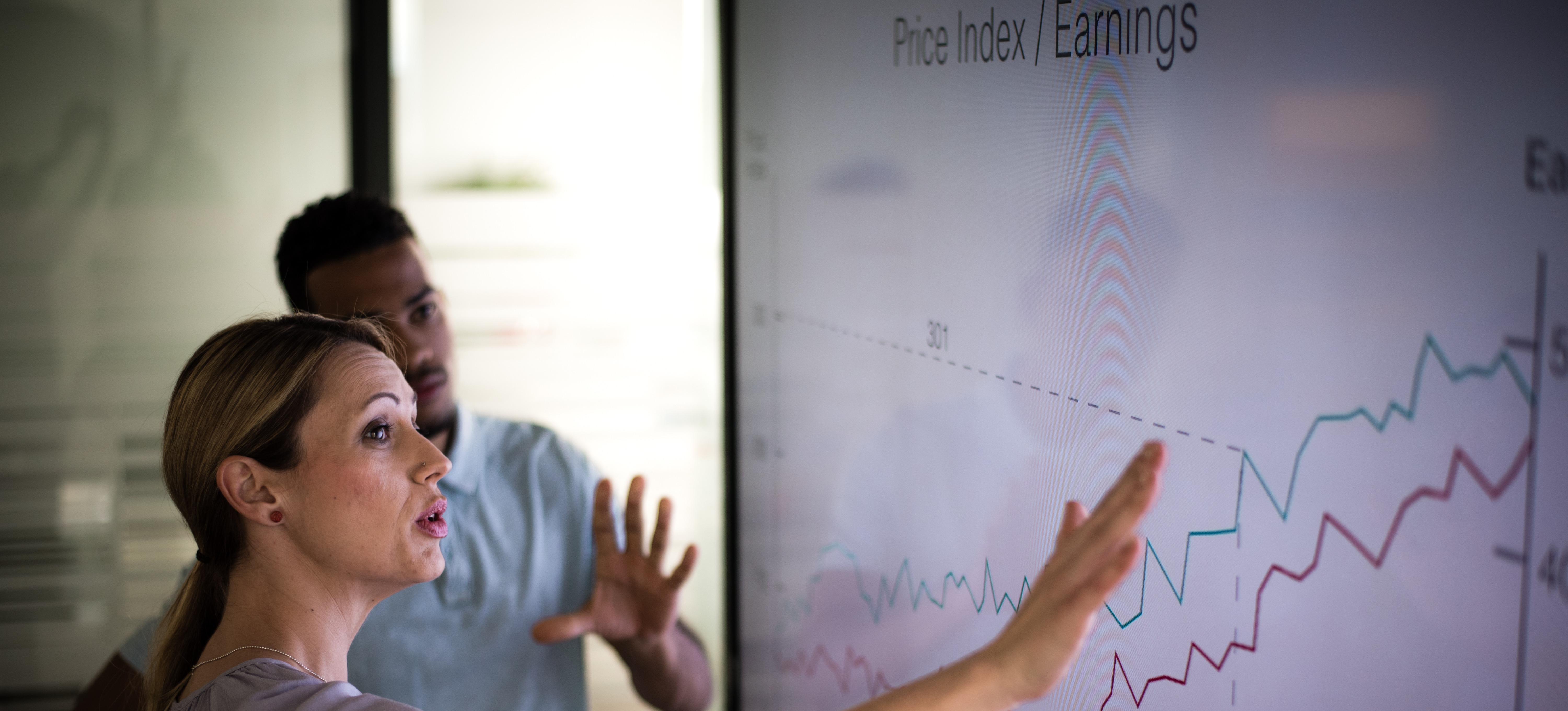 [Featured Image]:  Project Manager, approaching  and analyzing the latest project with a team member.