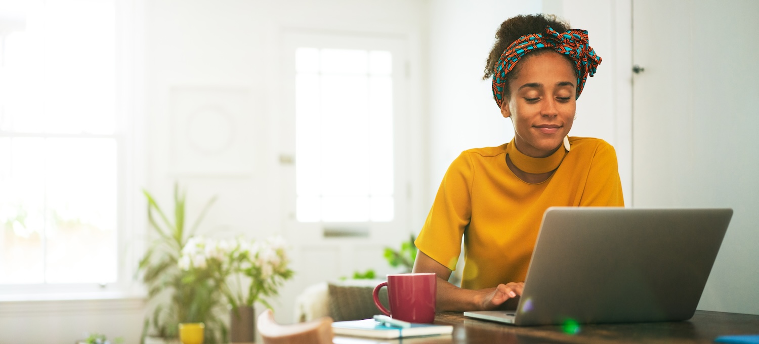 [Featured image] A person in a gold sweater sits at their kitchen table, looking at their laptop and searching about whether the college you go to matters.
