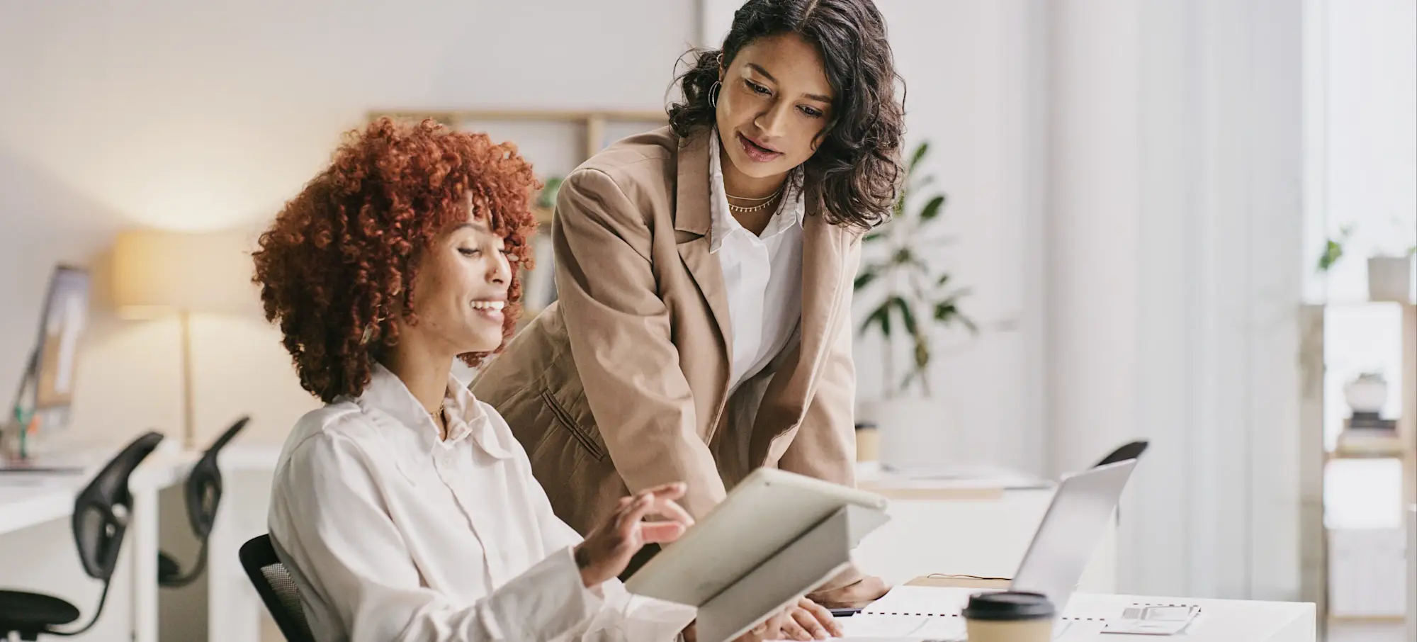 [Featured Image] A case manager meets with their supervisor at a desk to discuss a client. 