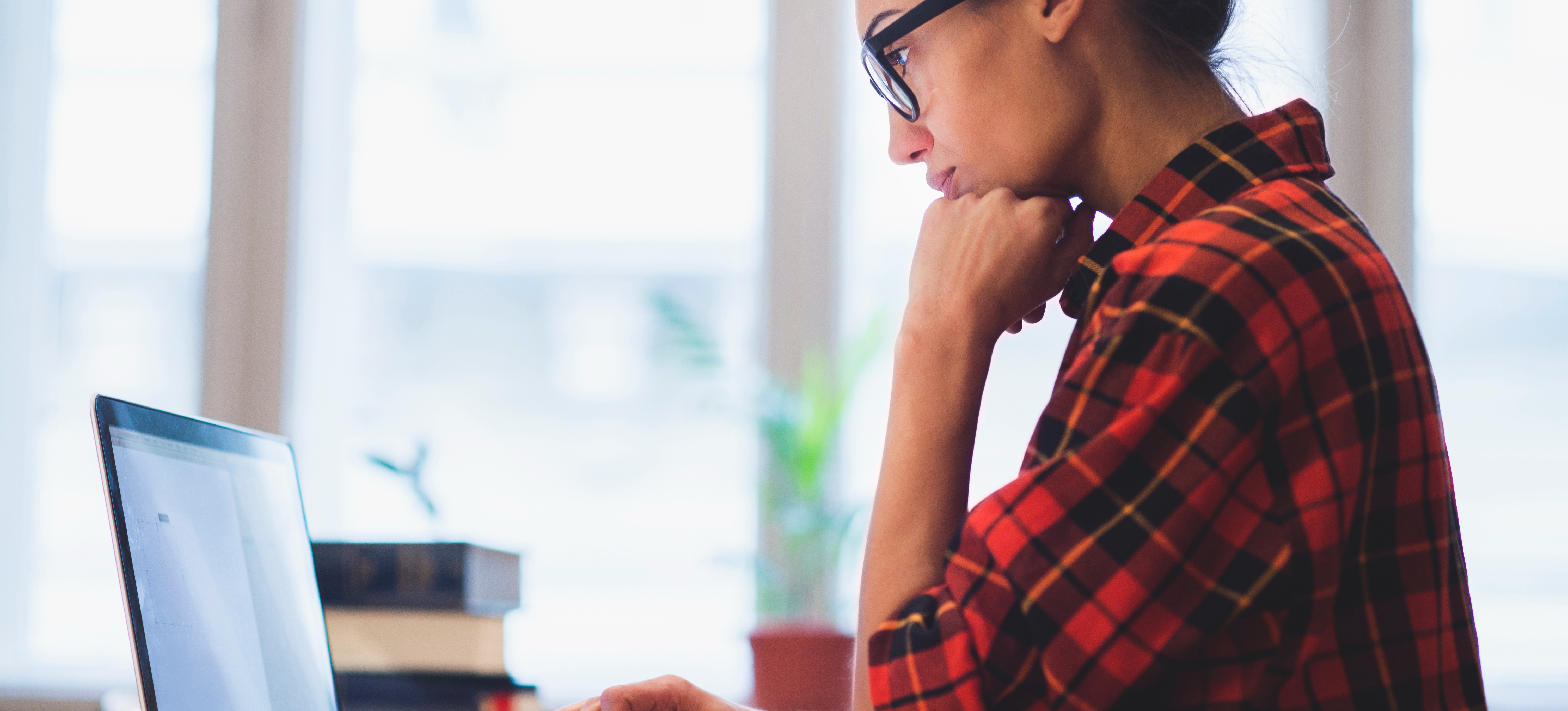 [Featured Image]: A person uses a laptop to compare the GMAT and GRE exams and choose the right one to take.