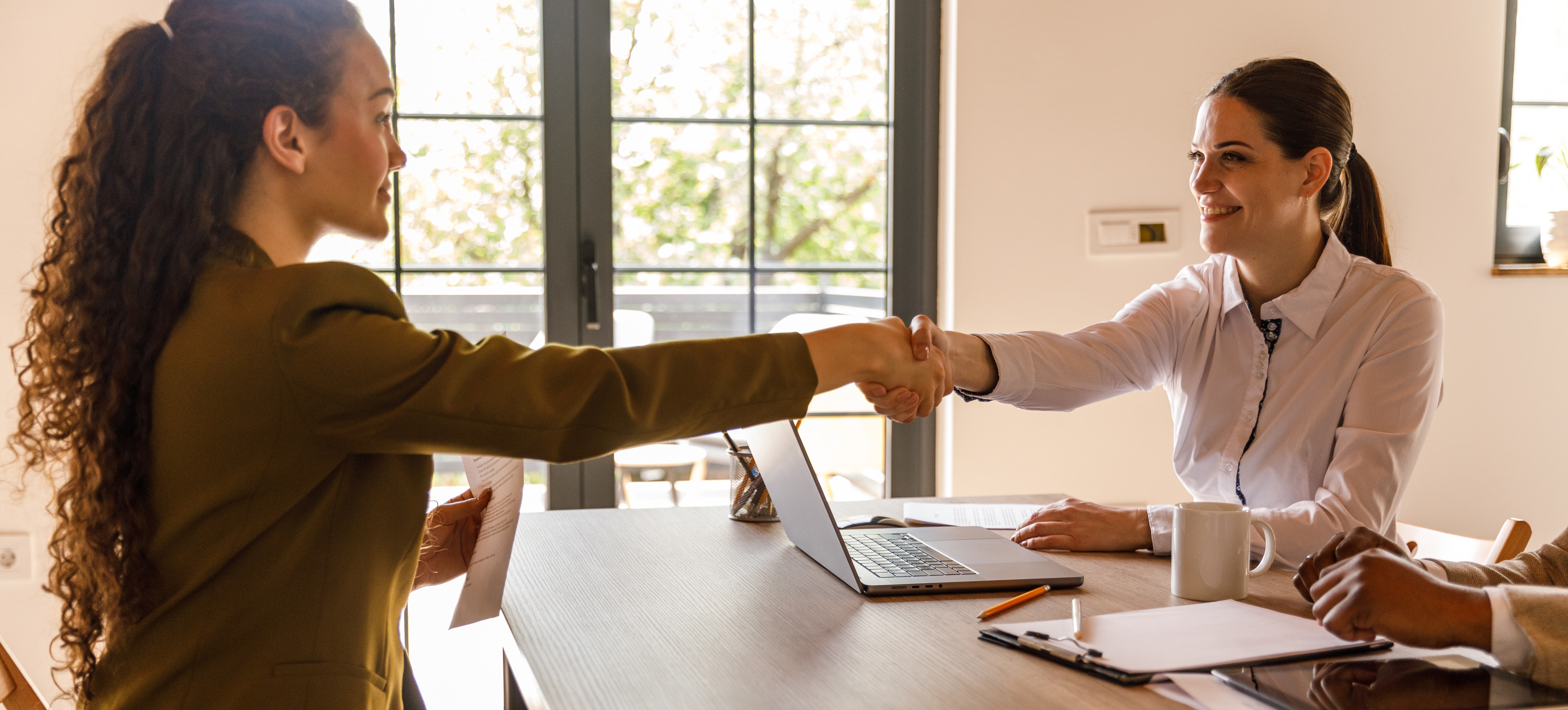 [Featured Image] A recruiter meets with a potential hire in an office setting.
