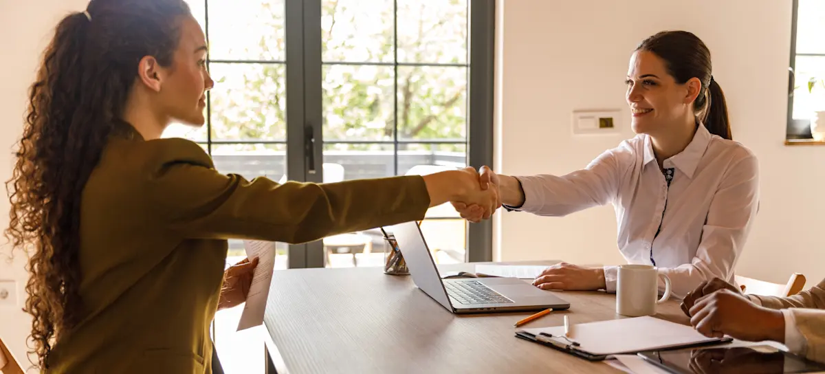 [Featured Image] A recruiter meets with a potential hire in an office setting.
