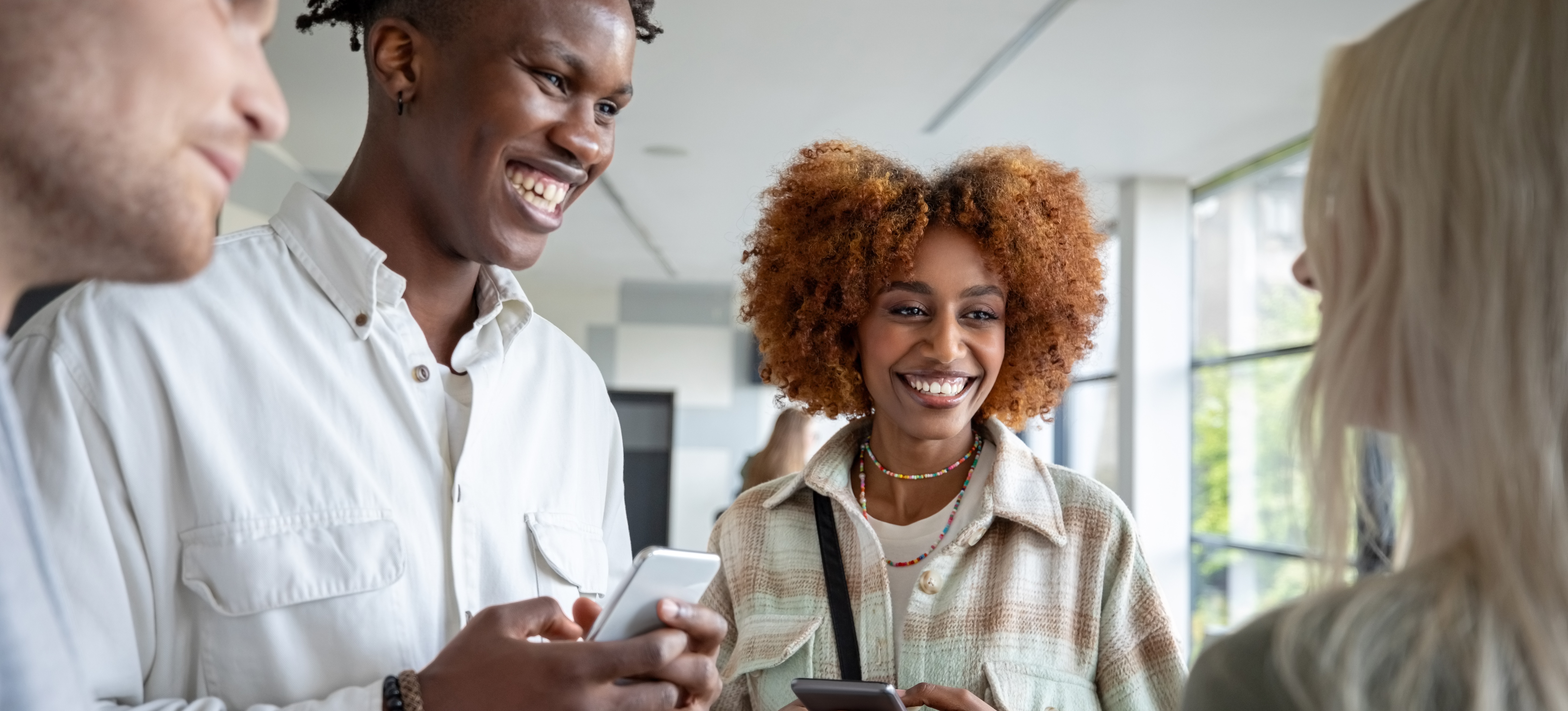 [Featured image] Four smiling college students discuss their college entry using the UCAS.