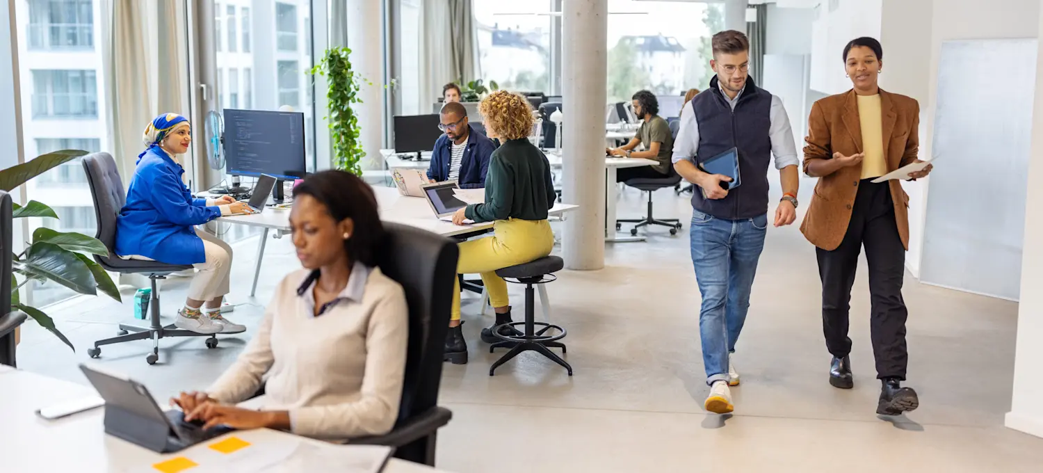 [Feature Image] Two machine learning engineers walk through a business office while discussing object detection vs. image classification to choose the method best suited to their project.
