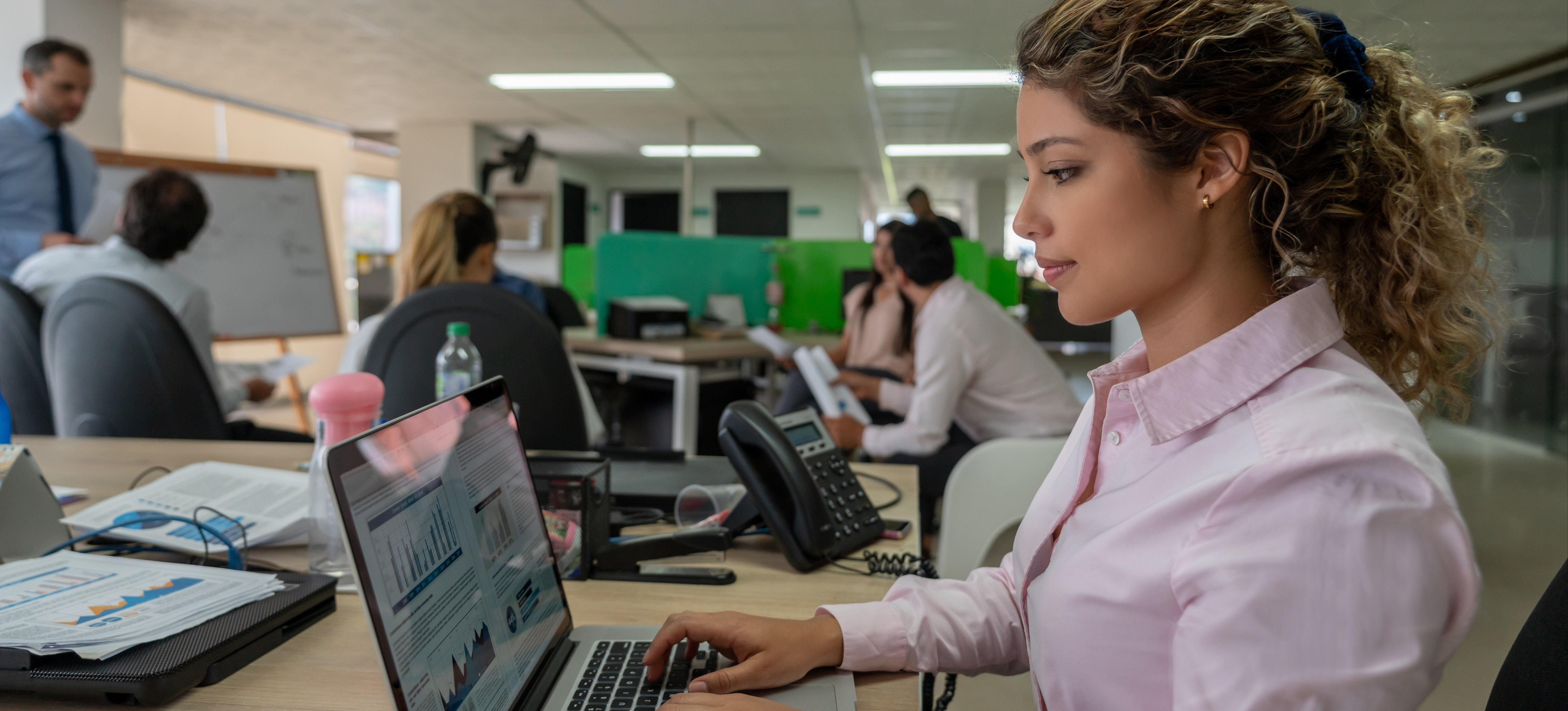 [Featured Image] An intelligence analyst, one of many FBI cybersecurity jobs, sits at a laptop and looks at data. 
