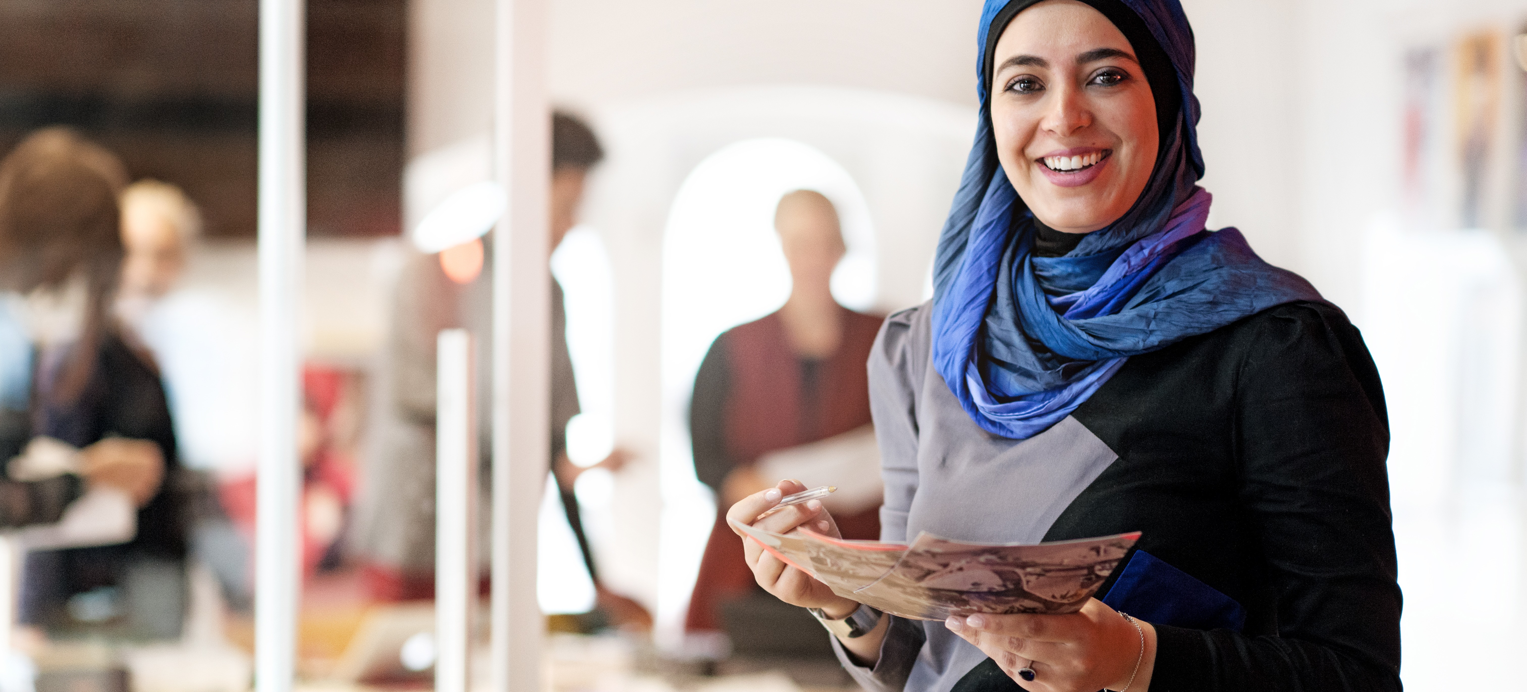 [Featured image] A sales associate holds a stack of product brochures.