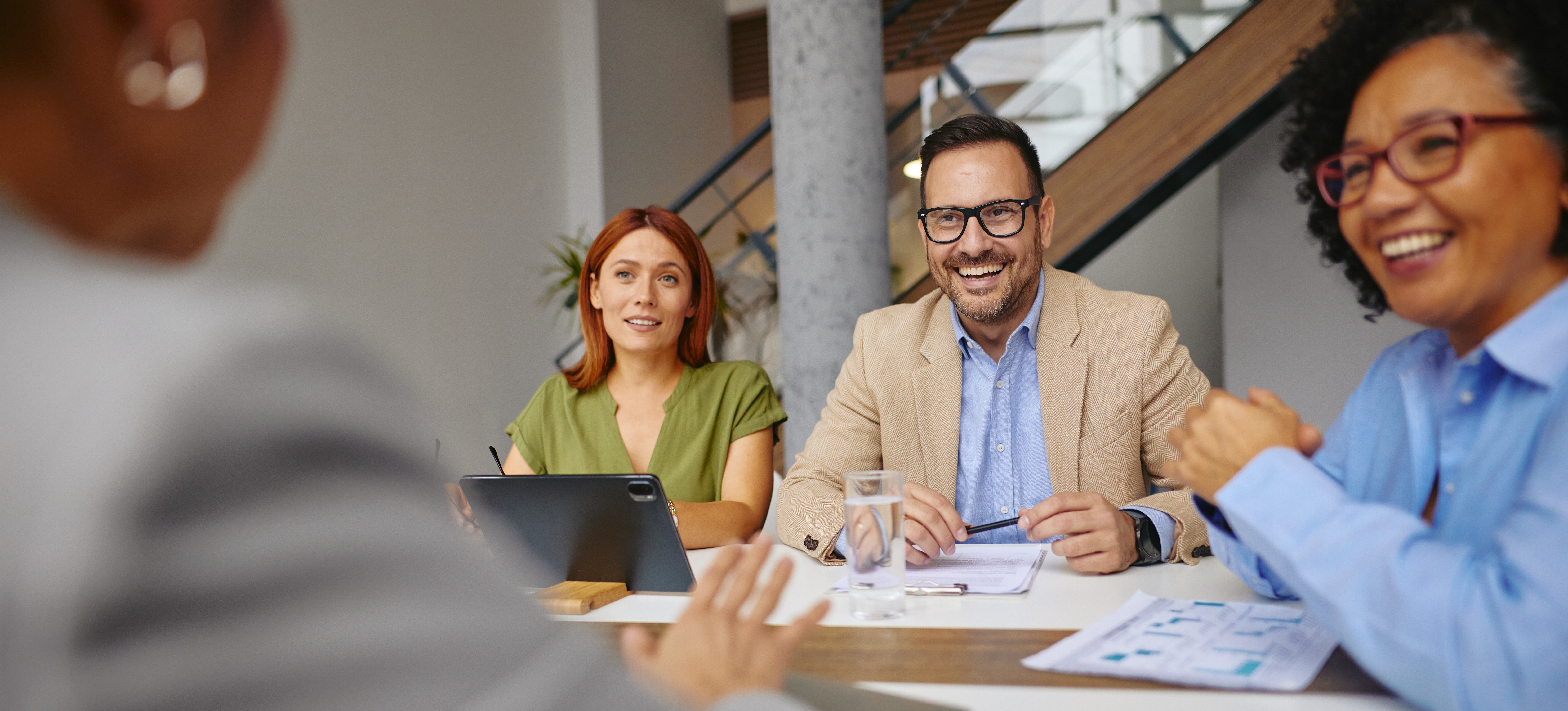 [Featured Image] A team working for a company that uses a matrix organization structure discusses a project together to come up with a common consensus on a solution.