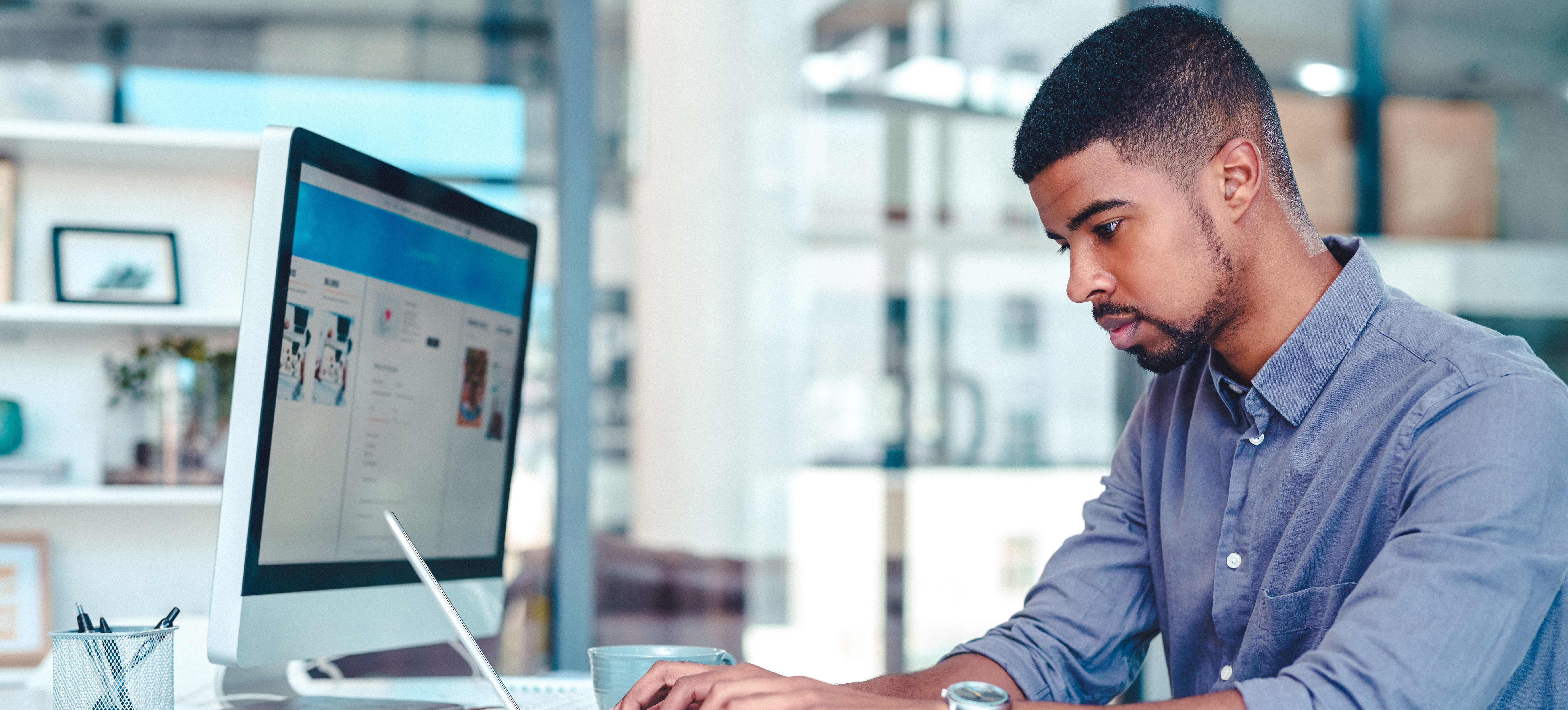 [Featured Image] A person intently focused on a computer screen looks up “What is Confluence” to learn more about its uses. 
