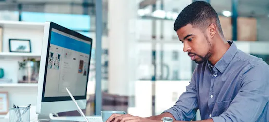 [Featured Image] A person intently focused on a computer screen looks up “What is Confluence” to learn more about its uses. 
