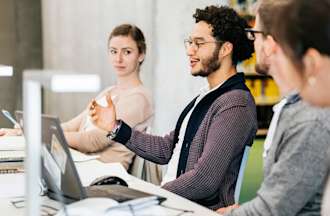 [Featured Image] A group of learners discuss various AI-related topics in a classroom, answering the question, “What are conditional generative adversarial networks?” 
