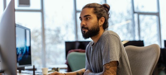 [Featured image] Big data engineer at computer working on organizing data