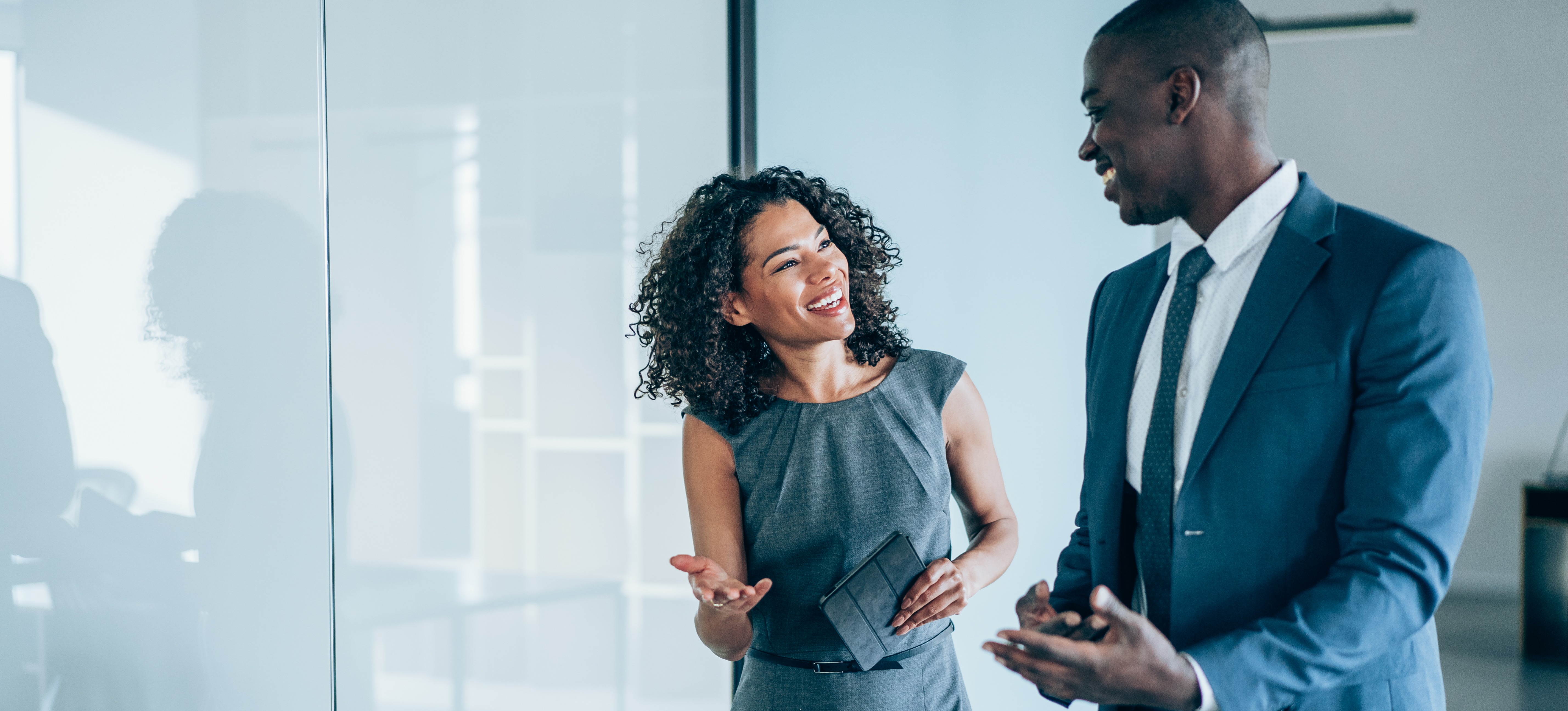 [Hauptbild] Ein lächelnder Manager führt ein Führungscoaching mit seinem Kollegen durch, der kürzlich befördert wurde.