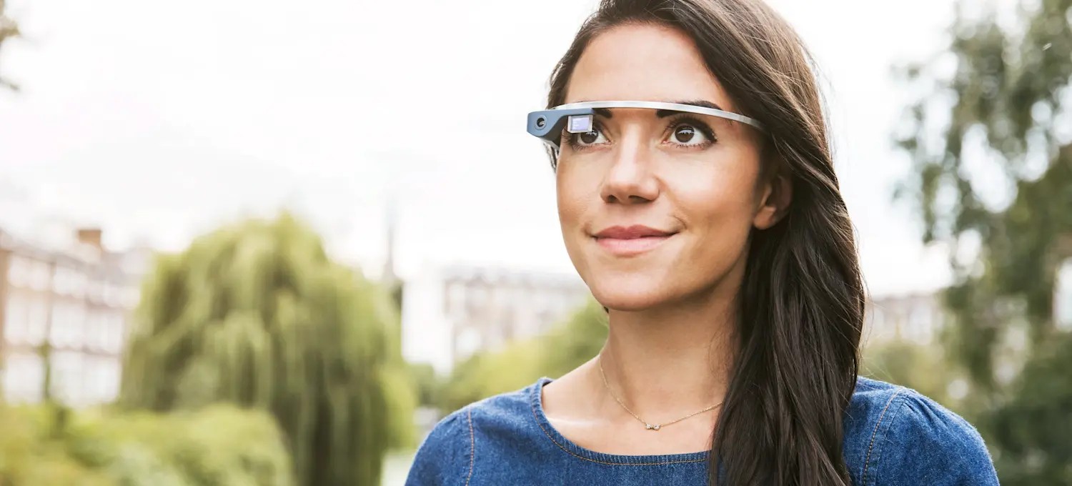 [Featured Image] A person stands outside wearing augmented reality (AR) glasses.  