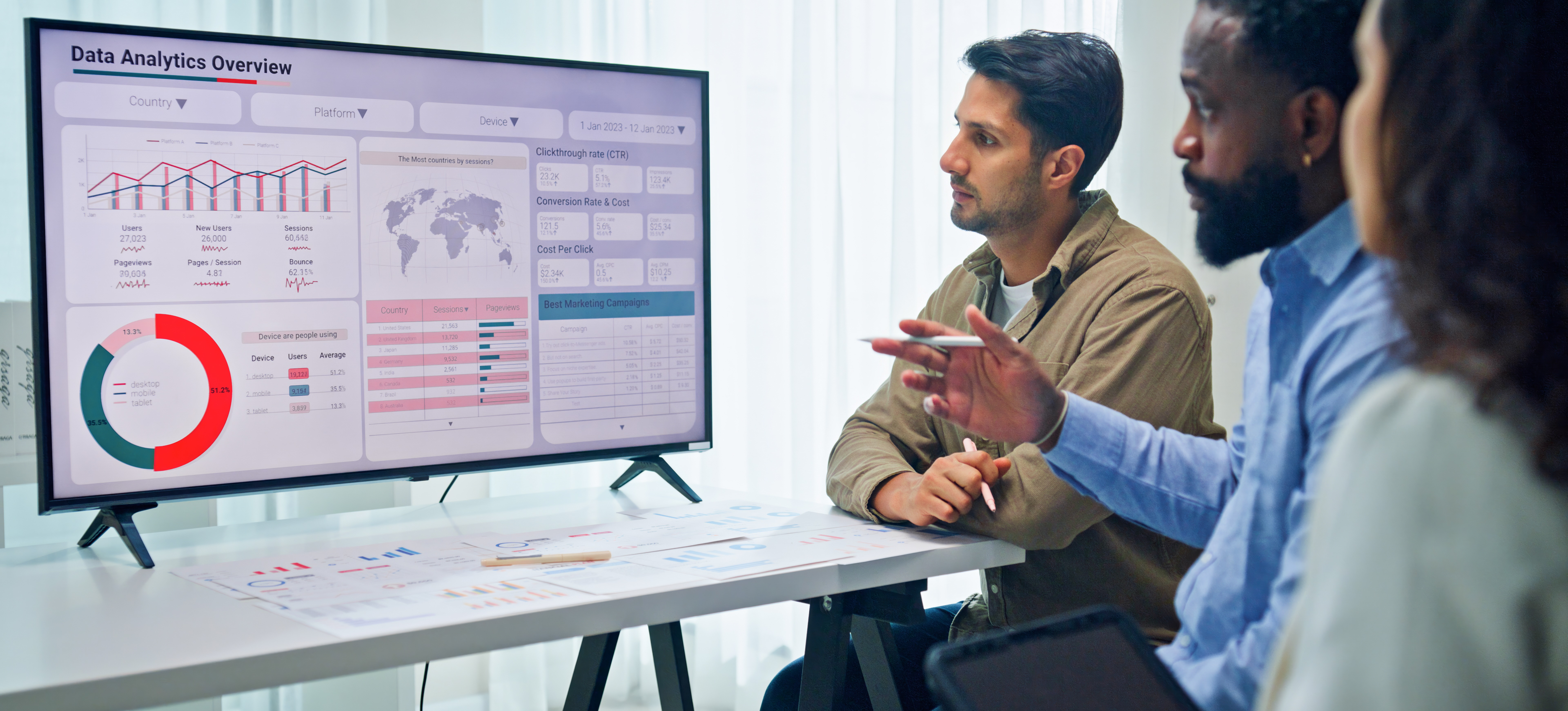 [Featured Image] IT professionals in a work environment reviewing data management charts on a TV while discussing Data Stewardship and Data Governance.

