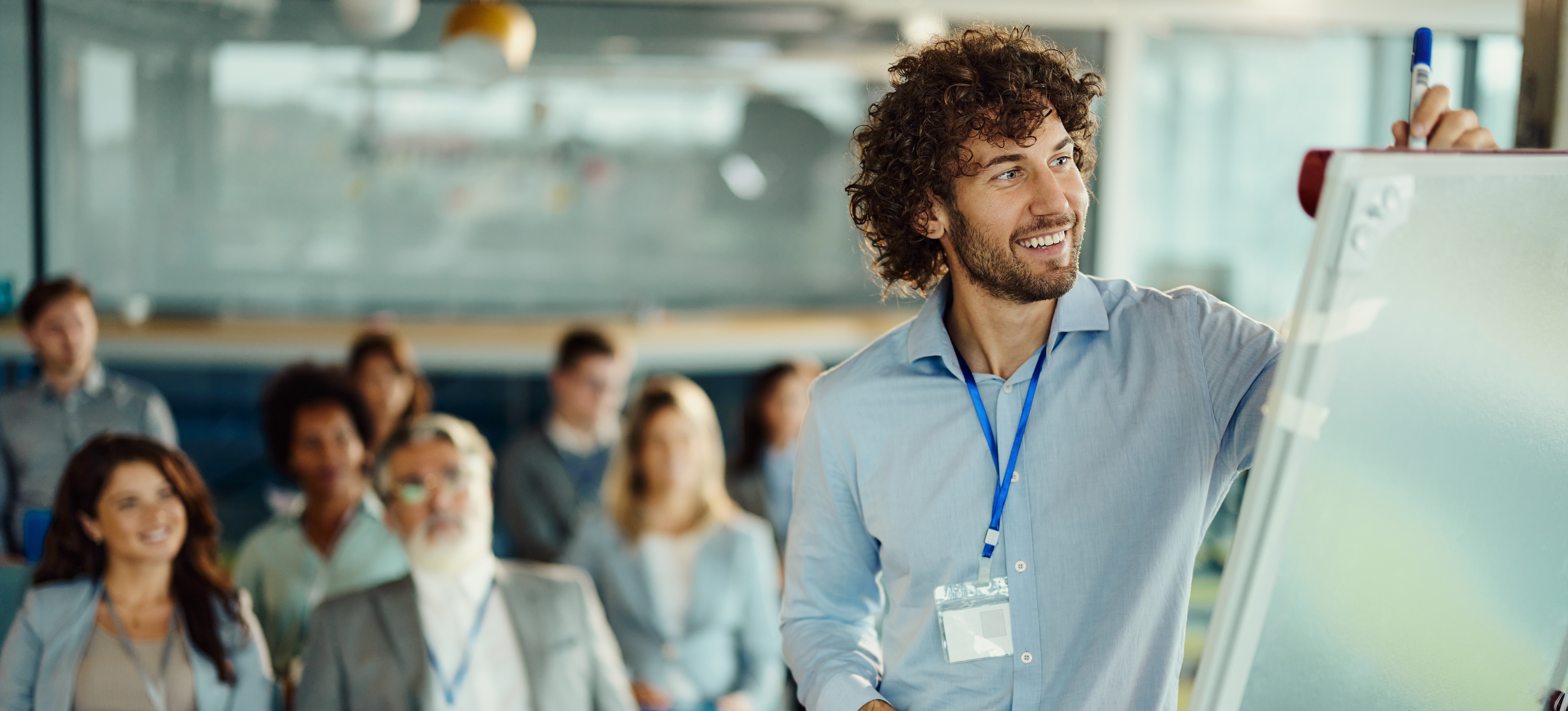 [Hauptbild] Ein Manager leitet eine Schulung mit einer Gruppe von Mitarbeitern, nachdem er gelernt hat, wie man eine Schulungsbedarfsanalyse durchführt.