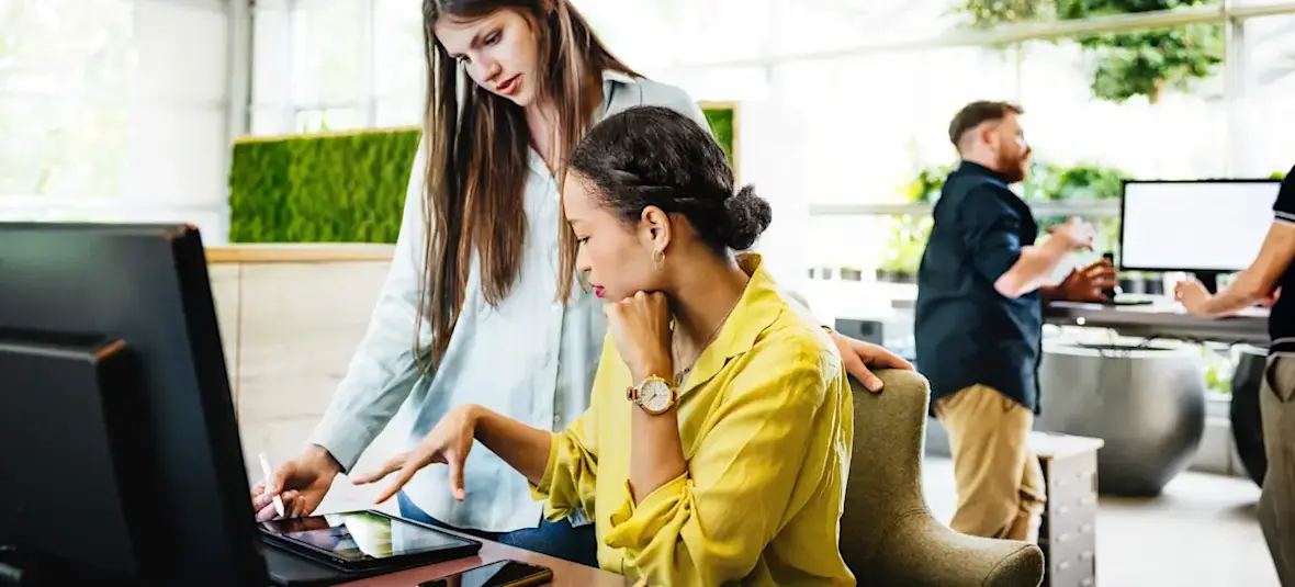 [Featured image] Two data analysts collaborate in an office and use the Snowflake data cloud storage to store their data.
