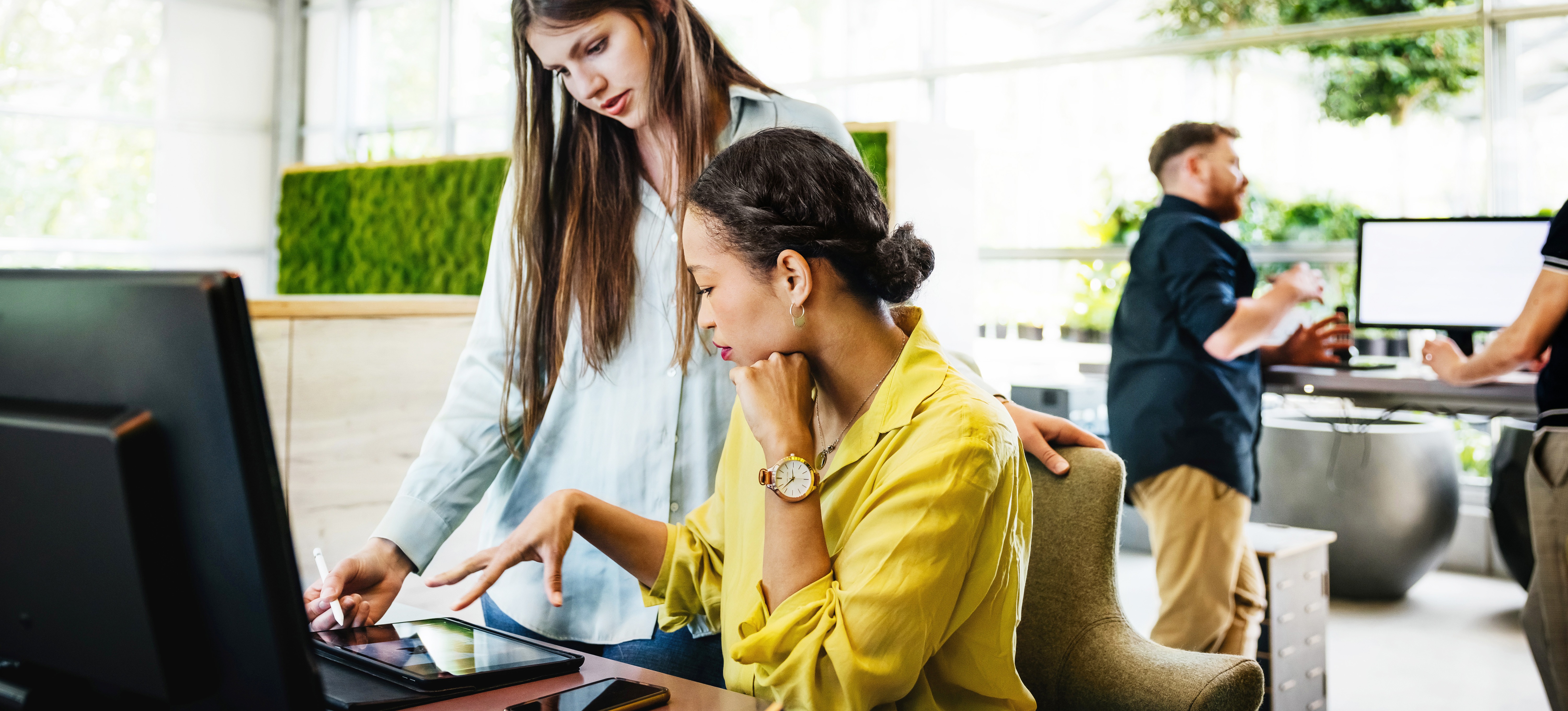 [Featured image] Two data analysts collaborate in an office and use the Snowflake data cloud storage to store their data.
