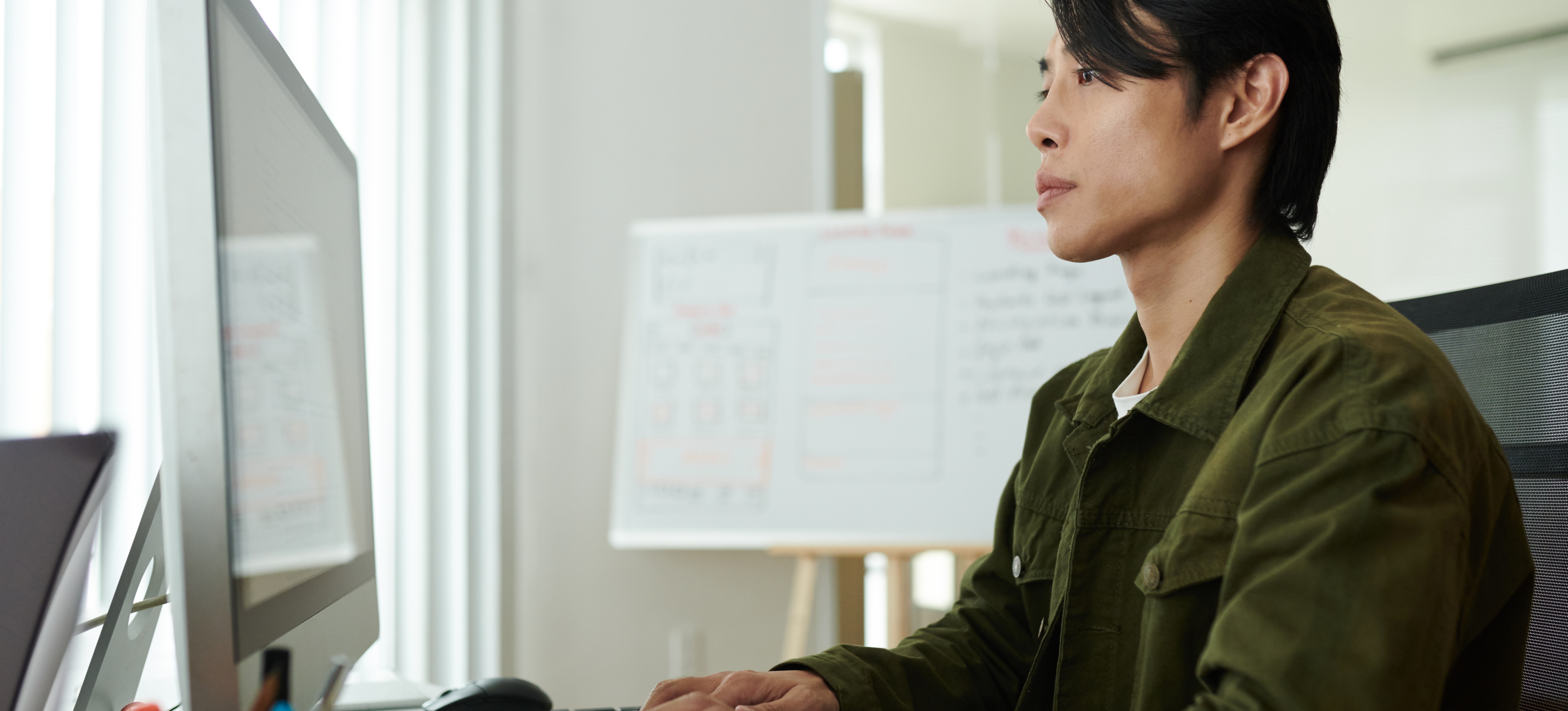 [Featured Image] A cloud engineer researches the best way to learn Kubernetes on their computer in a well-lit office space.