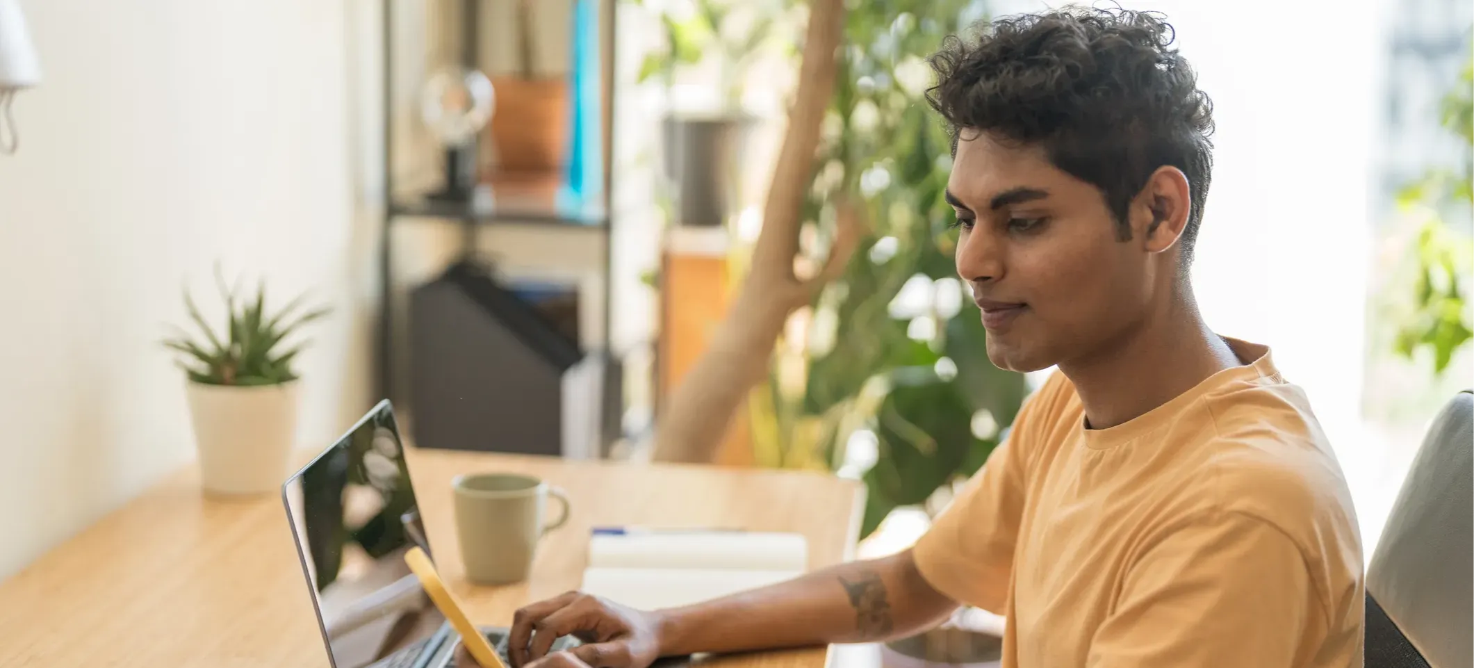 [Featured Image]: A person sitting in front of a laptop holds a phone to get help from a ChatGPT tutor.
