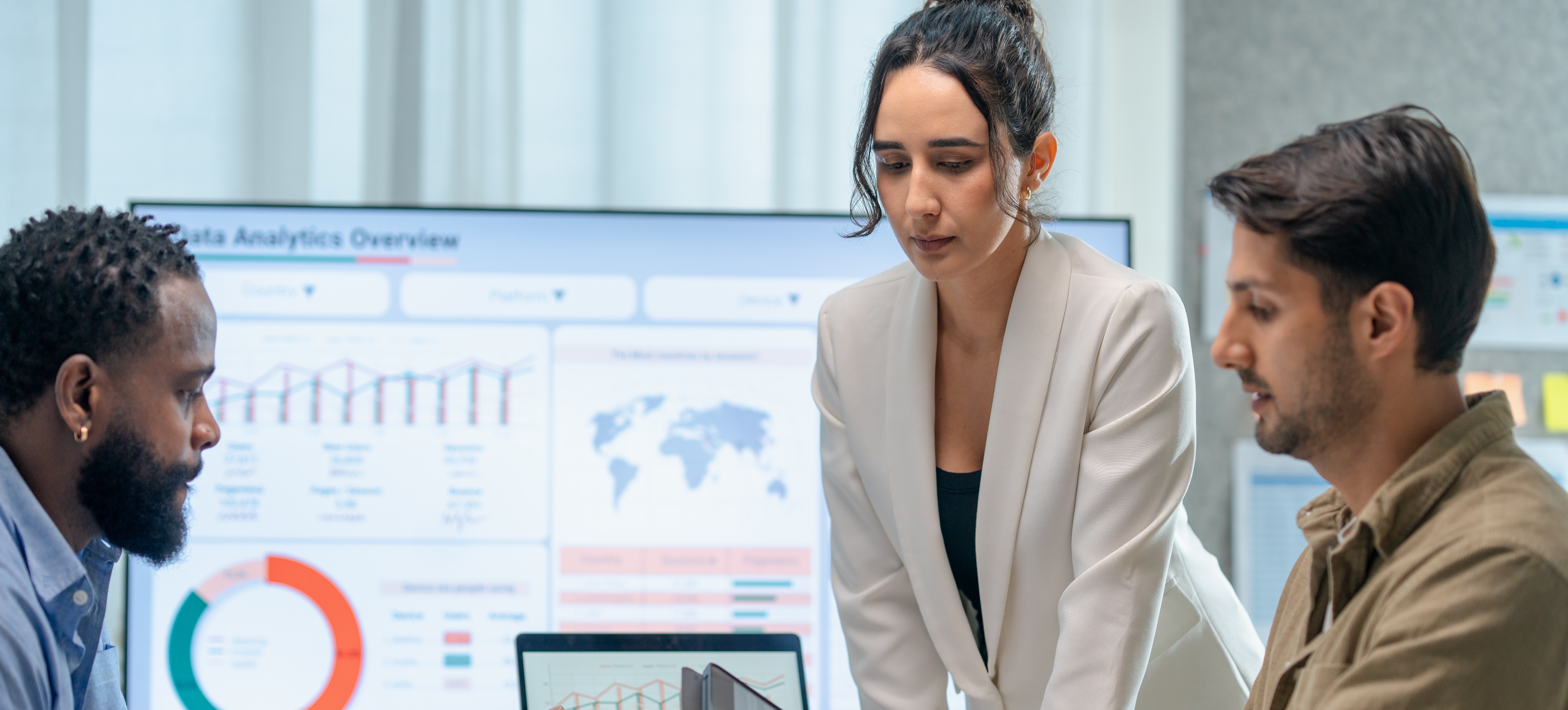 [Featured Image] Three data analysts discuss data types while looking at their tablets, computer screens, and clipboard.

