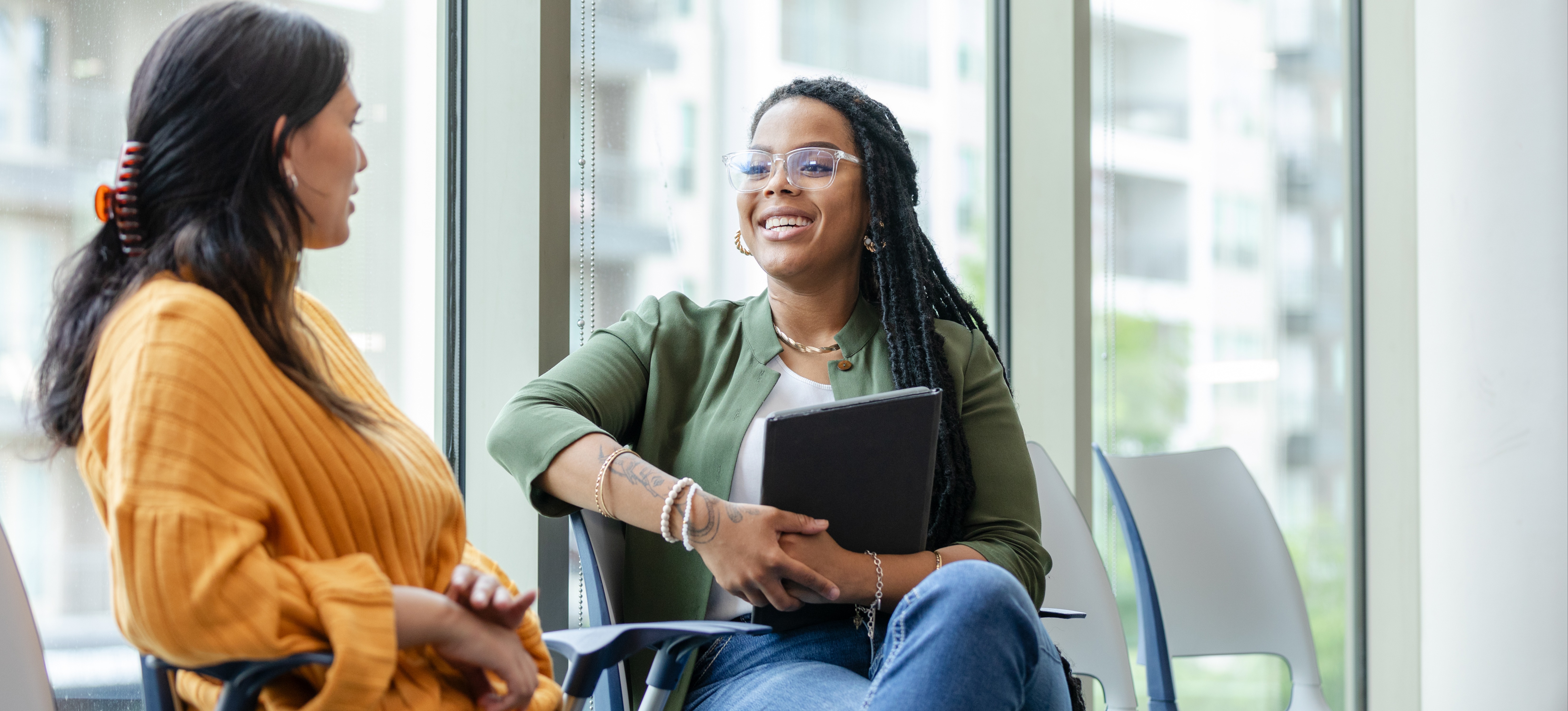 [Featured Image] A student sits with a careers advisor and talks to her about how to improve her low marks. 
