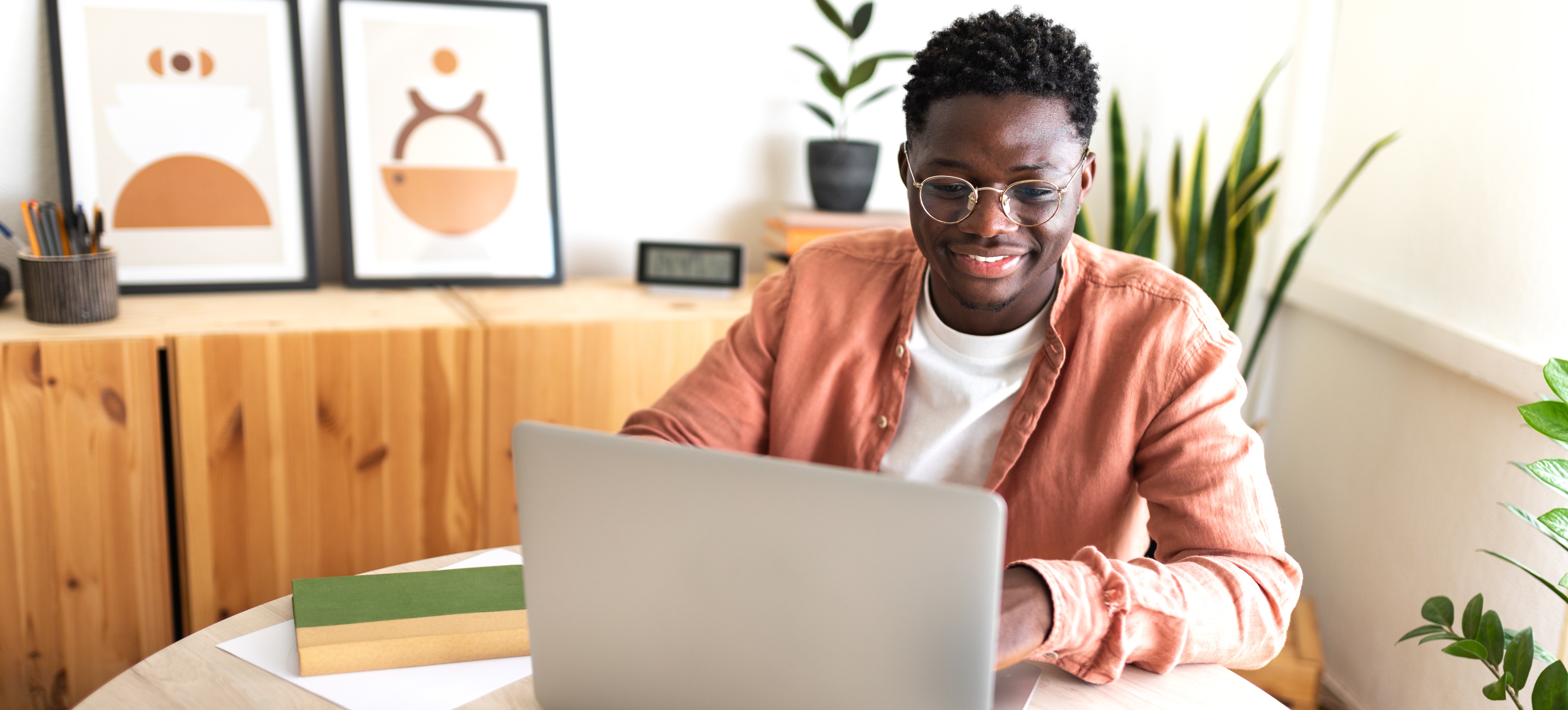 [Featured Image] A young man uses his laptop to learn about stackable credentials and how this option might be ideal for preparing for his future career plans. 
