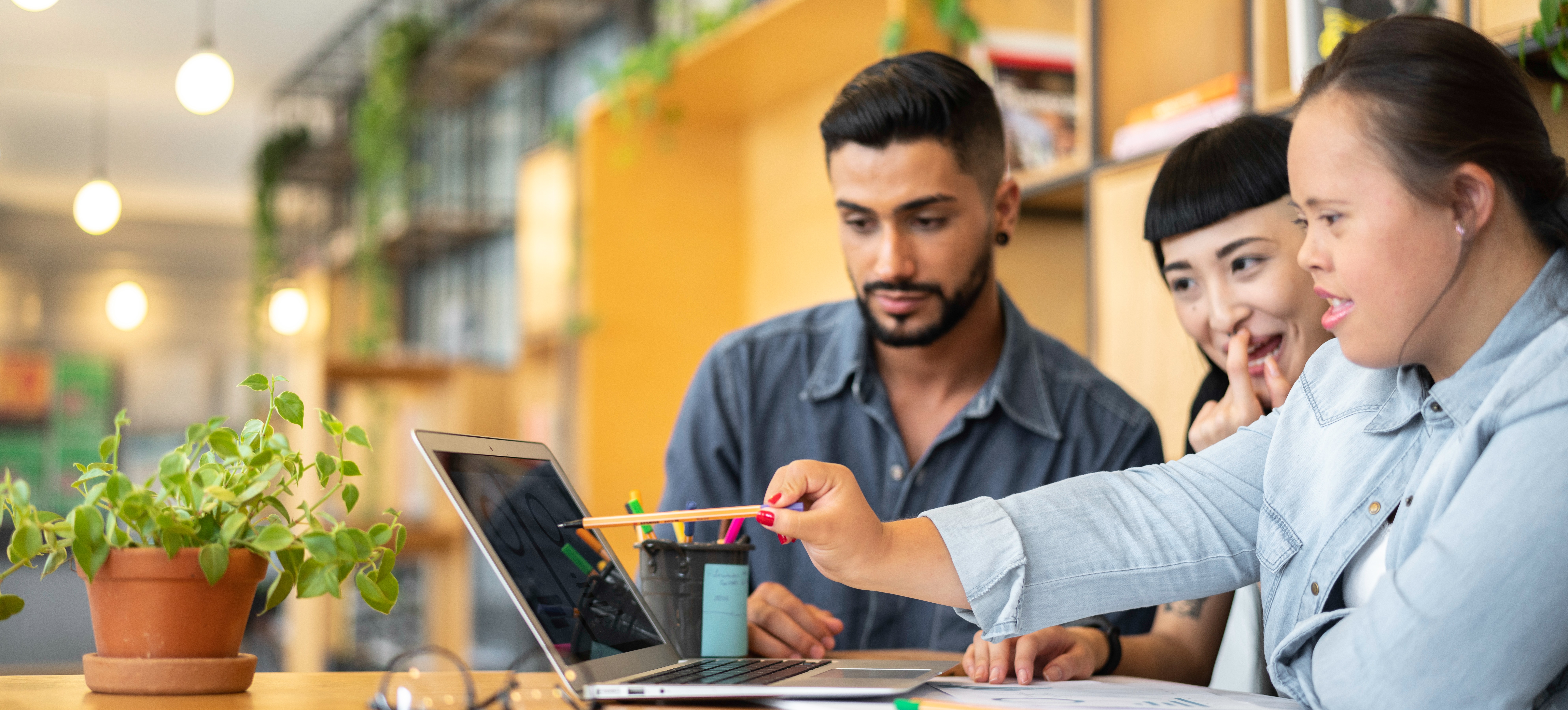[Featured Image] Young business people in an office setting look at a laptop as one person points to the screen, and they discuss link analysis.
