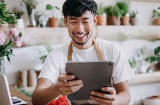 [Featured image] The owner of a plant store sets up a Google Merchant Center account on a tablet.