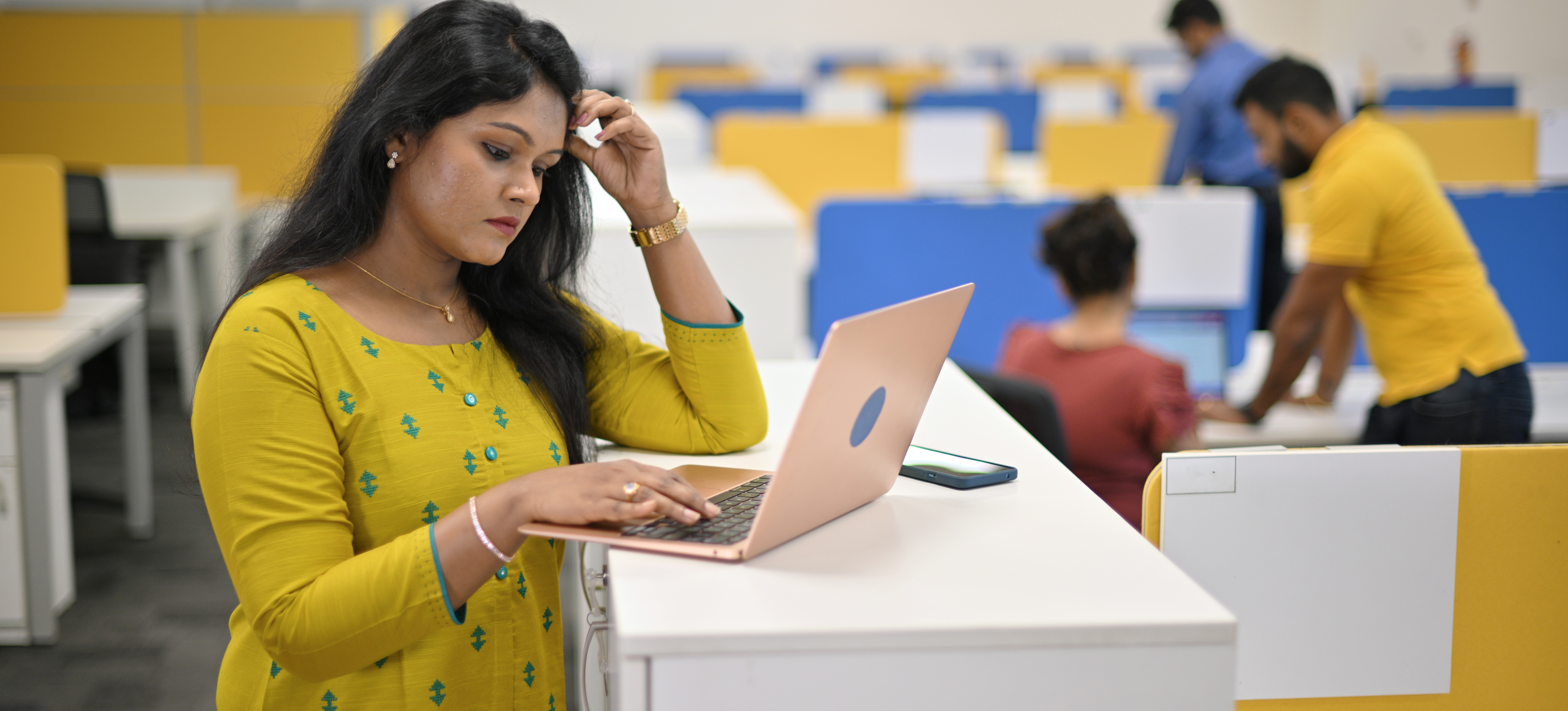 [Featured image] A data scientist is looking at a computer monitor and thinking as they stand in their office space. 