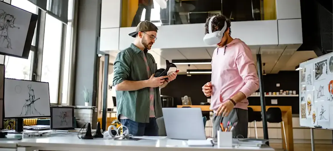 [Featured Image] Two augmented reality professionals design in an office, with one wearing an AR headset.